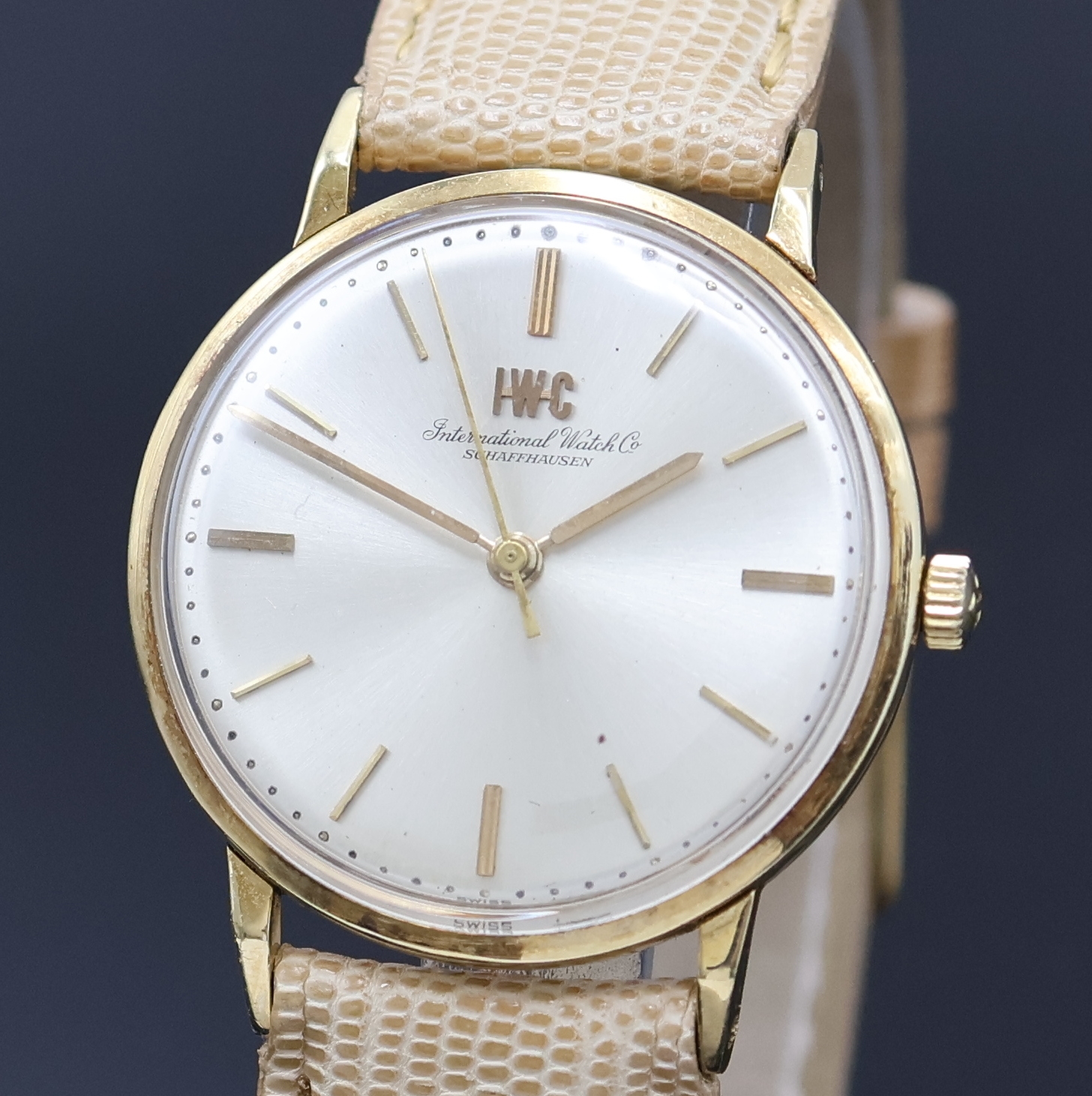Detail a: IWC Herrenarmbanduhr in GG 750/000, Schweiz um 1962, Handaufzug, 3-tlg. Geh., Boden (dell.) u. Glasrand aufgedr., silb. Zifferbl. m. aufges. gold. ...