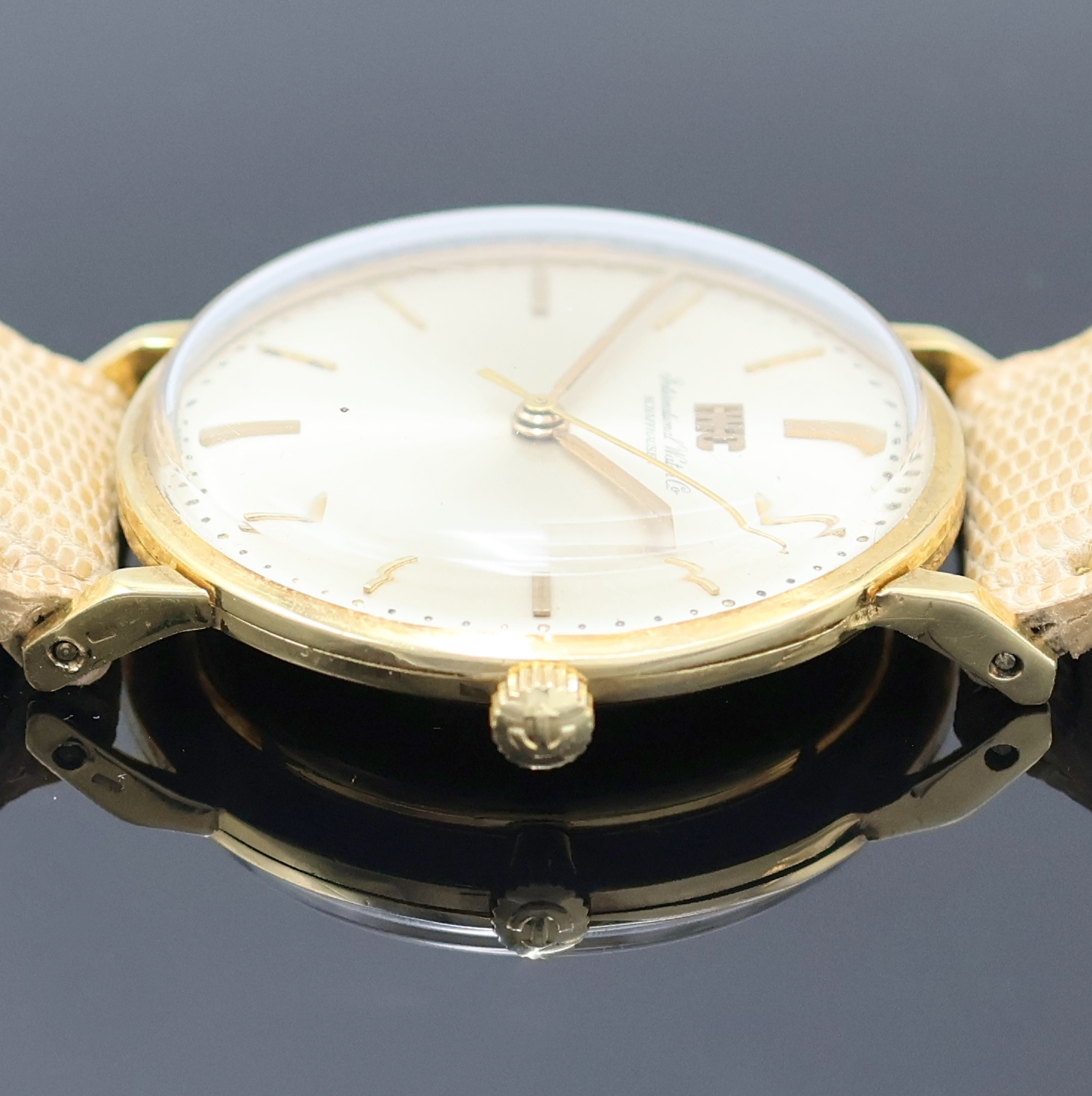Detail c: IWC Herrenarmbanduhr in GG 750/000, Schweiz um 1962, Handaufzug, 3-tlg. Geh., Boden (dell.) u. Glasrand aufgedr., silb. Zifferbl. m. aufges. gold. ...