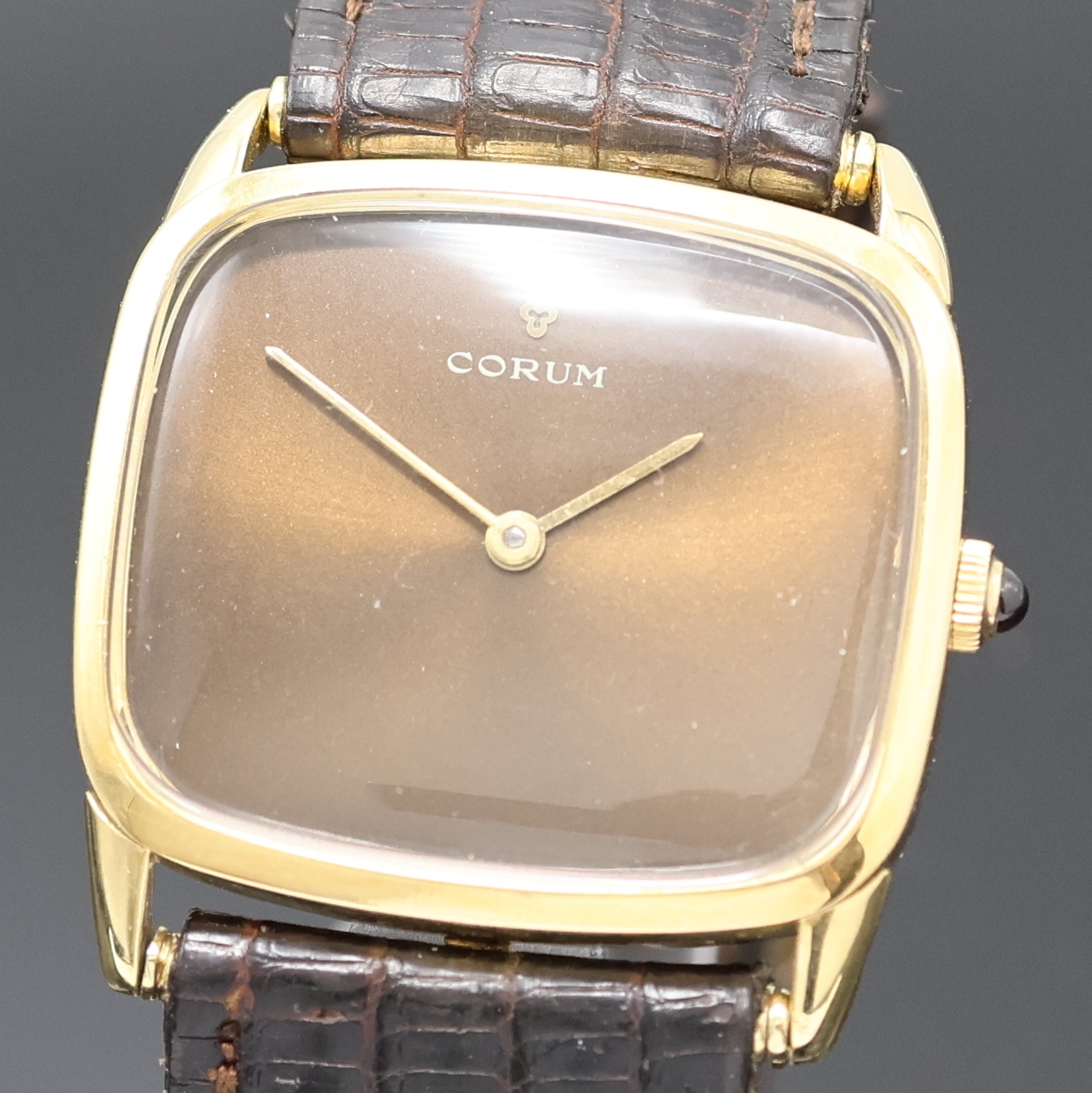 Detail a: CORUM Armbanduhr in GG 750/000, Schweiz um 1970, Handaufzug, 2-tlg. Geh., Boden aufgedr., orig. Krone m. Schmuckstein, braunes Zifferbl. am Rand ...