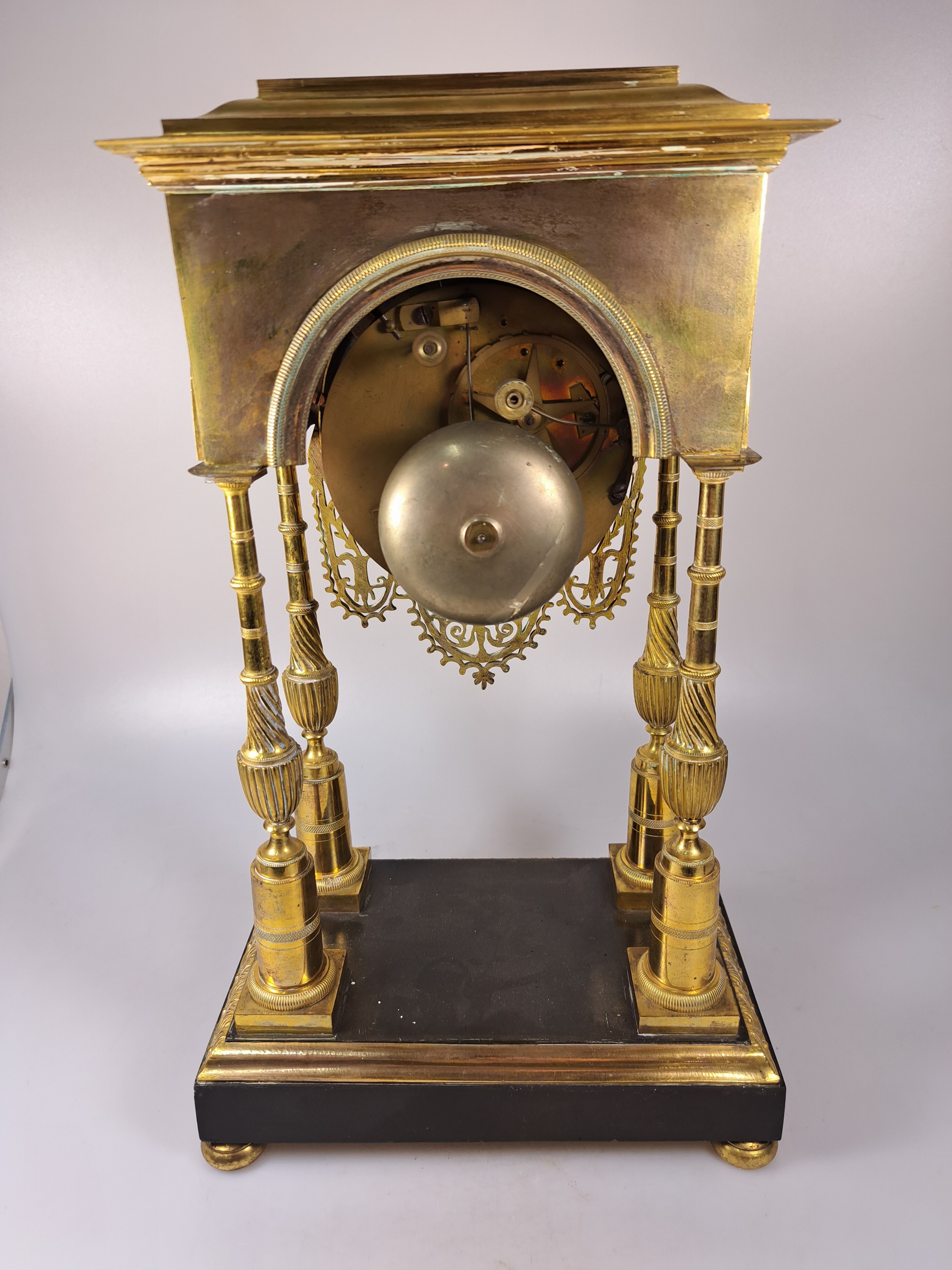 Detail e: Portaluhr, Frankreich, Mitte 19. Jh., Messinggehäuse verziert, Sockel brüniert, Uhr getragen von 4 filigranen Säulen, in den Ecken Palmetten, mit ...