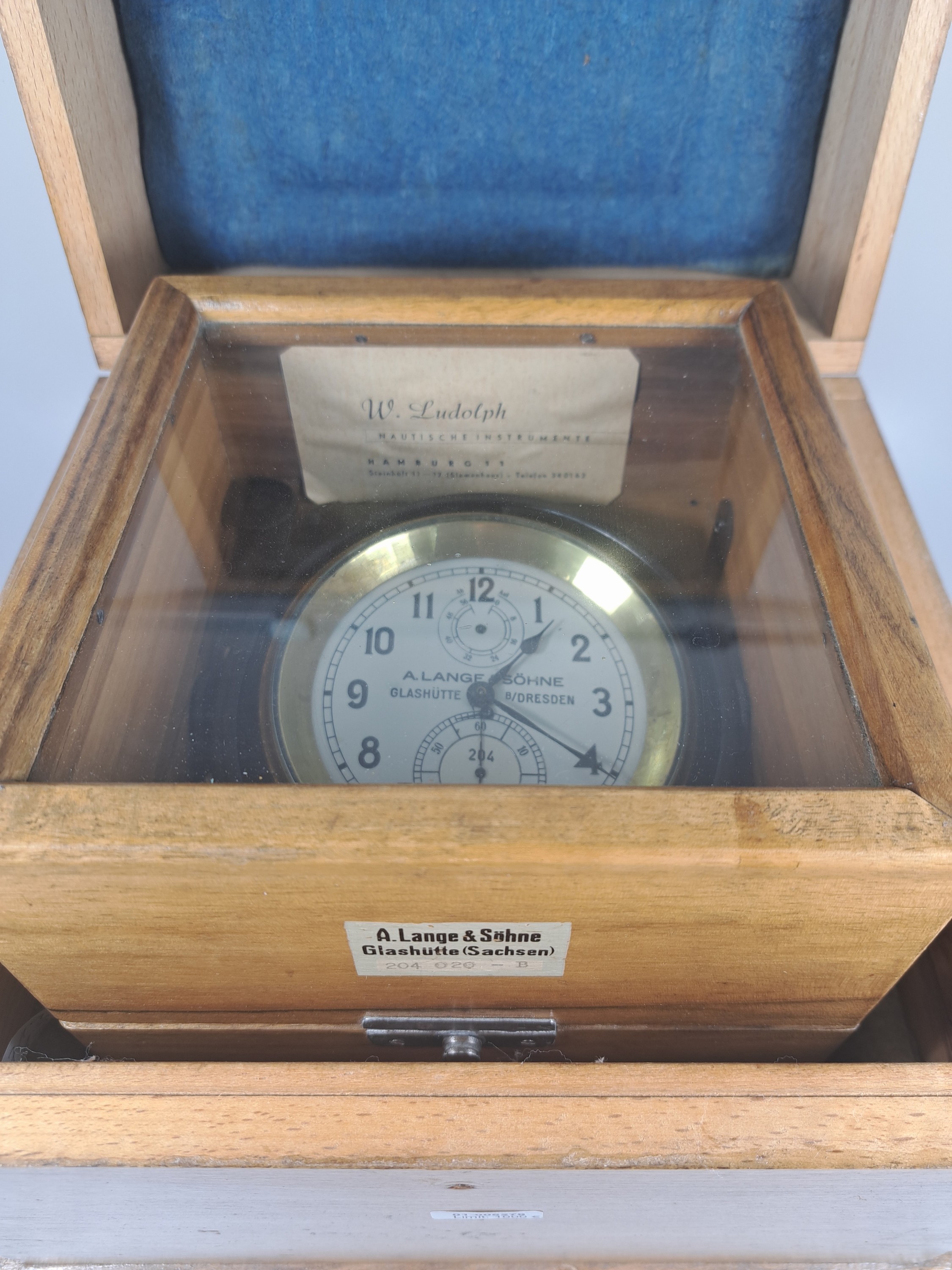 Detail i: Marinechronometer, Lange & Söhne, Glashütte, in doppeltem Holzkasten mit Lederriemen, Innendeckel verglast, Nr. 204 020 - B, seitlich eingelassene ...