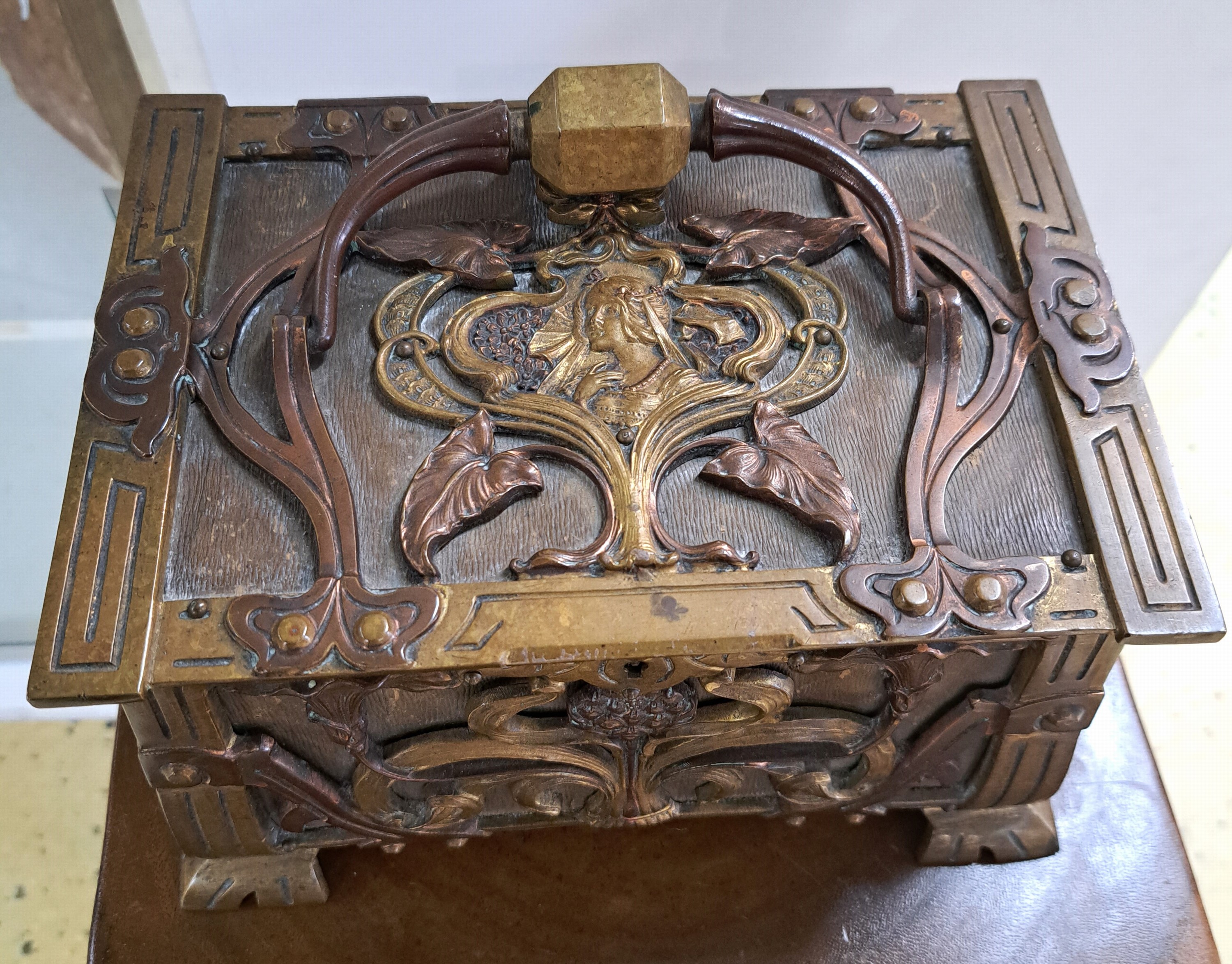 Detail b: Kleine Deckeltruhe des Jugendstils, um 1905/10, Bronze und Messing, reicher vollplastischer Dekor, mit grünem Samt ausgekleidet, 14x23x19 cm