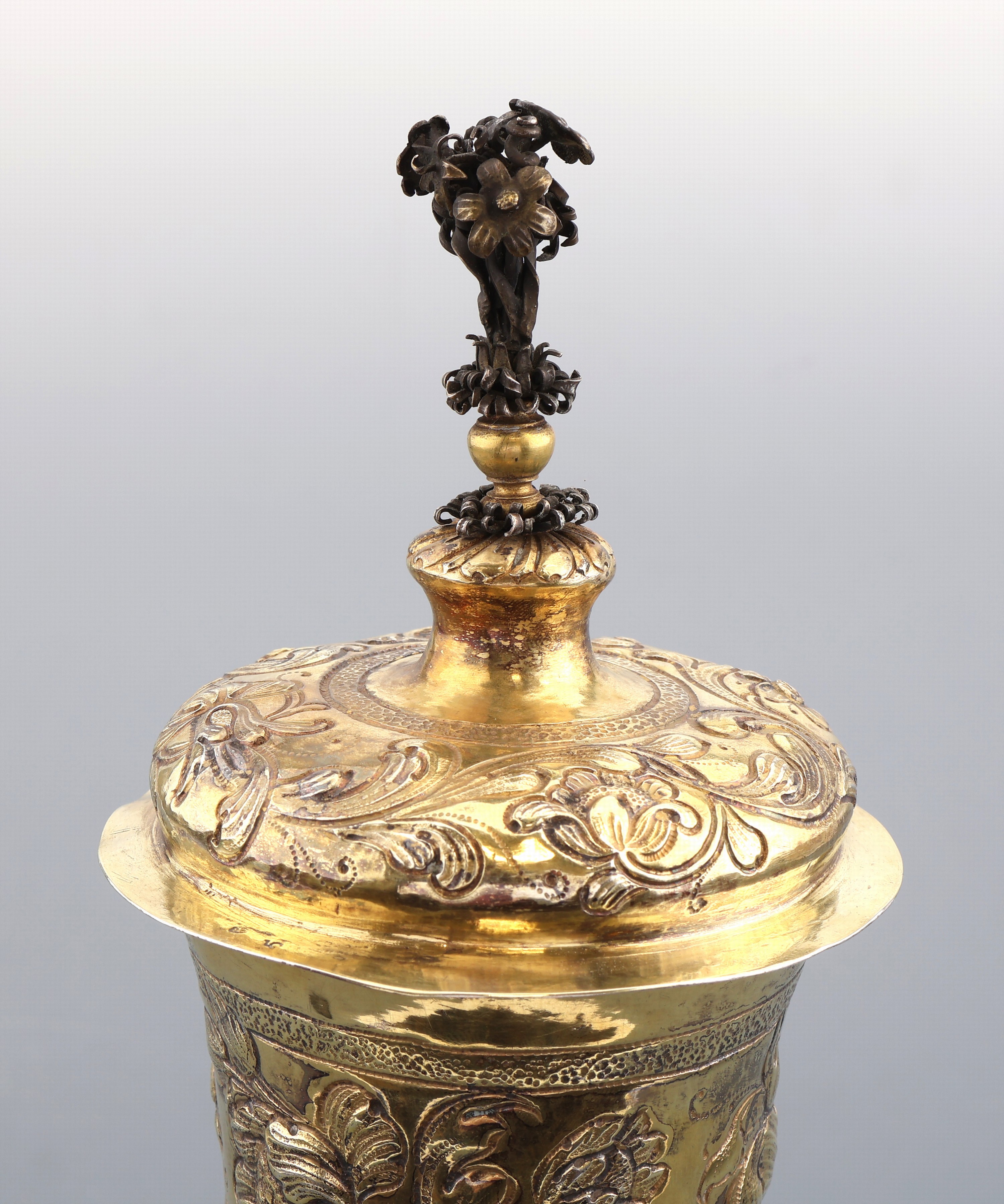 Detail a: Deckelpokal im Barockstil, Hanau um 1900, Silber vergoldet, leicht konischer Korpus auf profiliertem Fuß, reiche durchgehende getriebene und ...