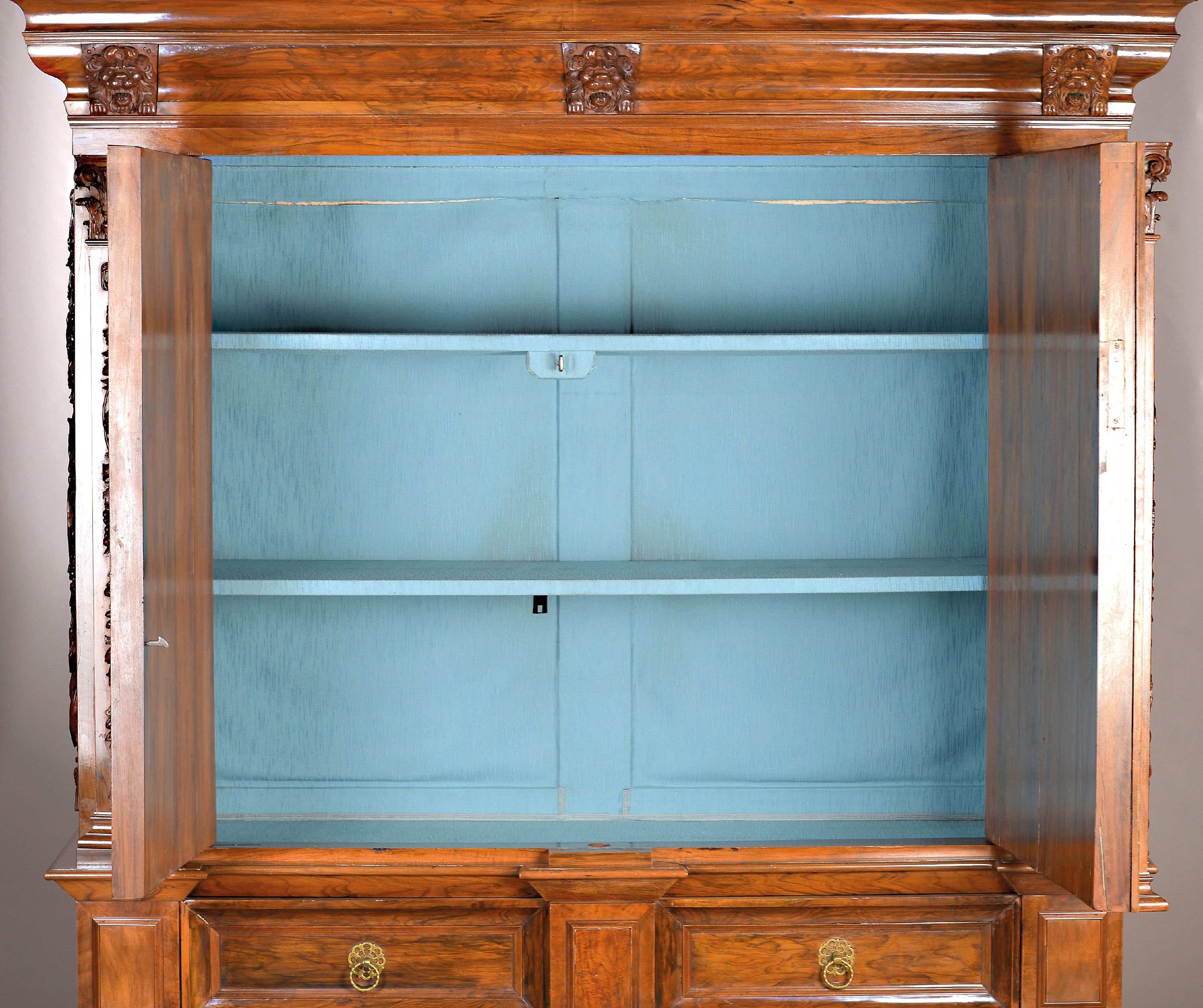 Detail a: Pilasterschrank, Niederlande, Ende 18./19. Jh., Nussbaumfurnier, z.T. massiv, aufgelegte Schnitzereien auf der Front, den aufgesetzten Kissen und den ...