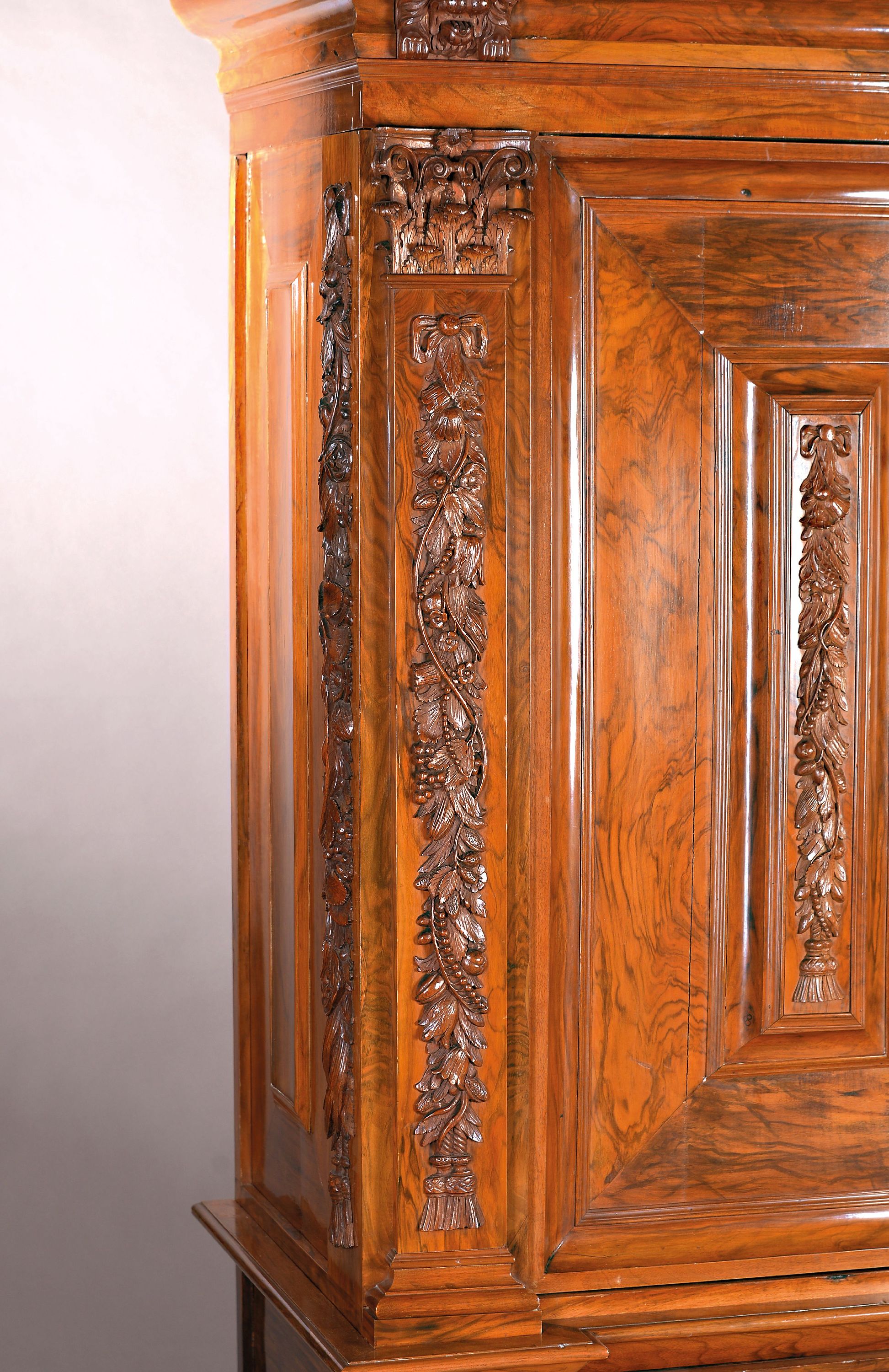 Detail b: Pilasterschrank, Niederlande, Ende 18./19. Jh., Nussbaumfurnier, z.T. massiv, aufgelegte Schnitzereien auf der Front, den aufgesetzten Kissen und den ...