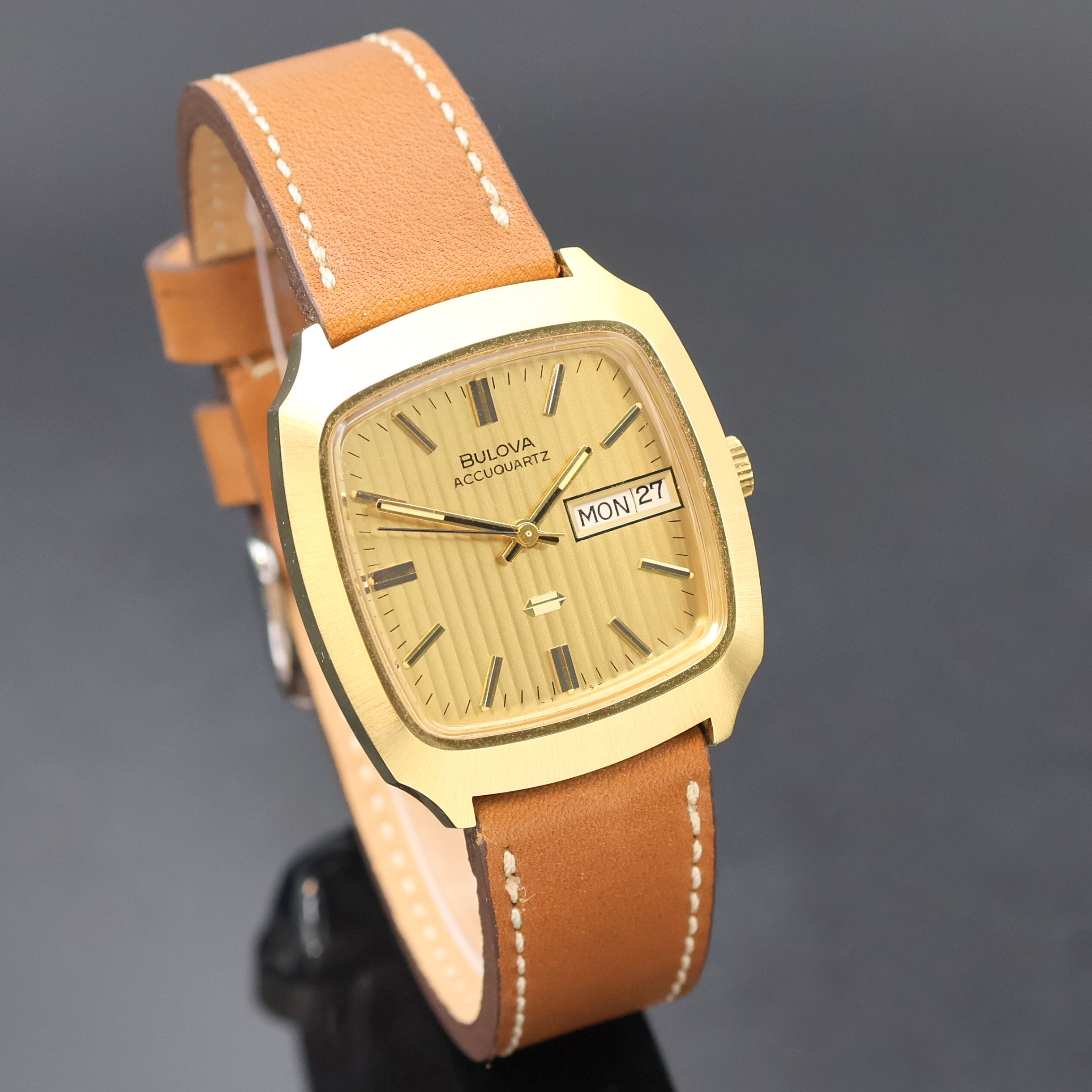Detail b: BULOVA Accuquartz Herrenarmbanduhr, Schweiz um 1970, verg. Metallgeh., Edelstahlboden verschr., gold. Zifferbl. mit Streifenschliff und aufges. ...