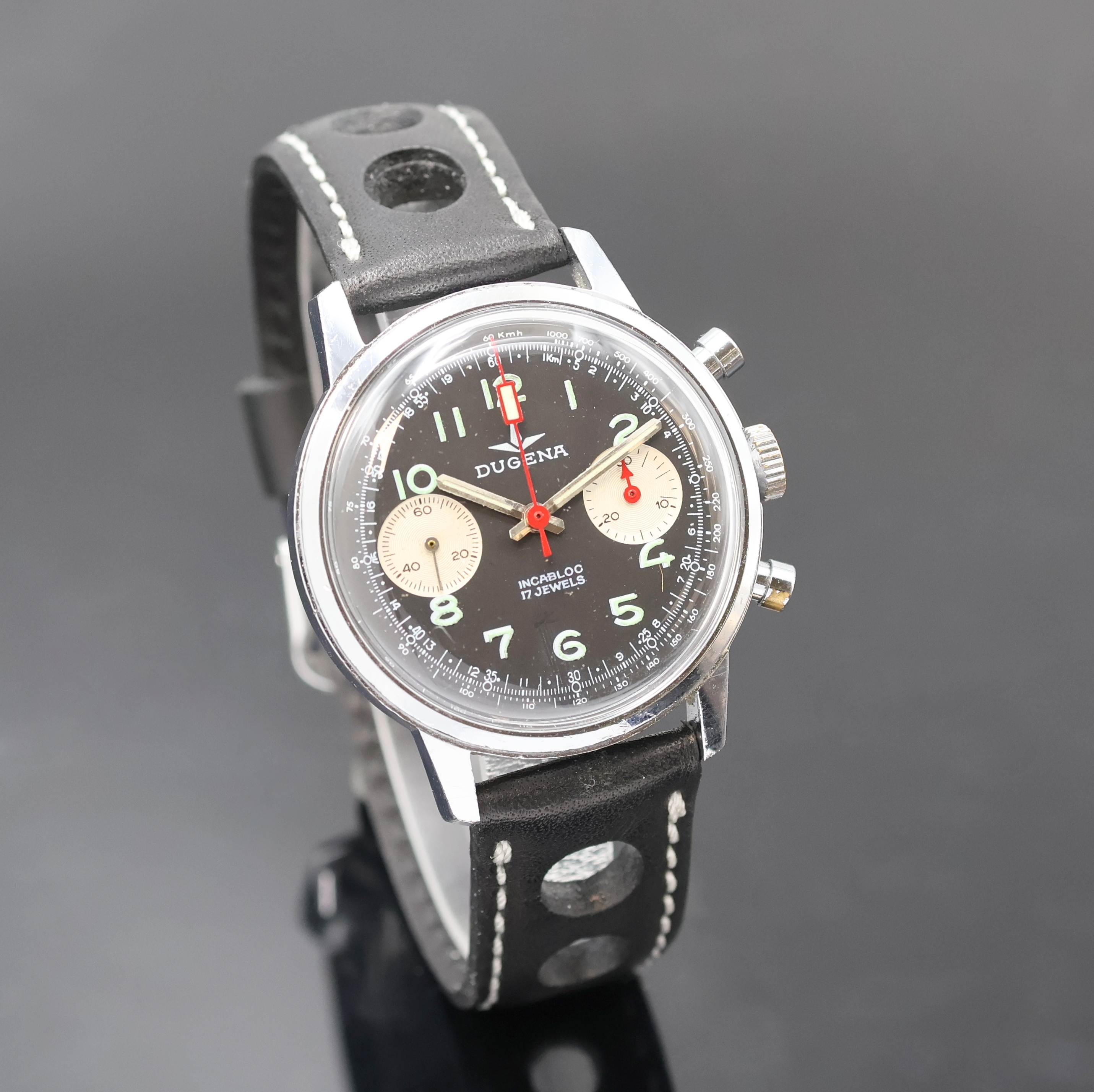Detail b: DUGENA Herrenarmbanduhr mit Chronograph, Handaufzug, Schweiz um 1970, verchr. Geh. m. verschr. Stahlboden, schwarzes Zifferbl. m. arab. Std., silb. ...