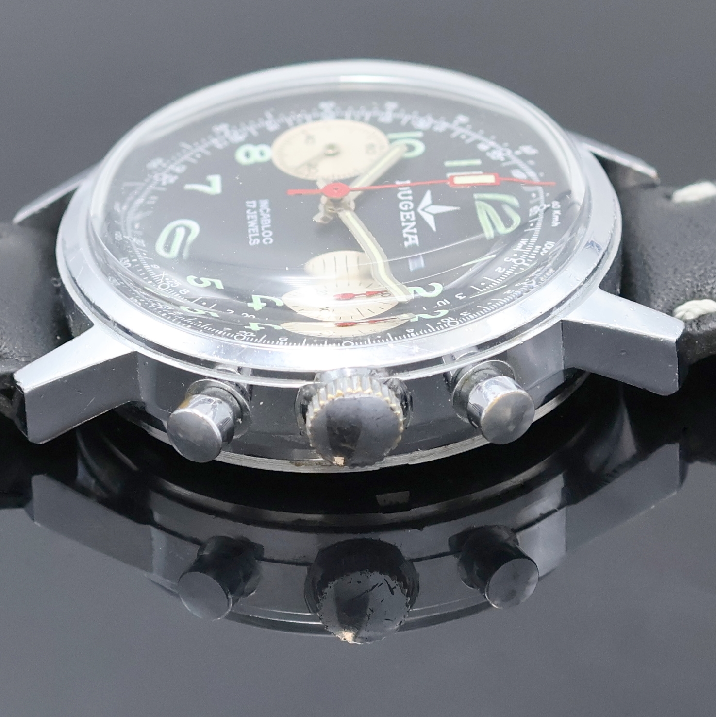 Detail d: DUGENA Herrenarmbanduhr mit Chronograph, Handaufzug, Schweiz um 1970, verchr. Geh. m. verschr. Stahlboden, schwarzes Zifferbl. m. arab. Std., silb. ...