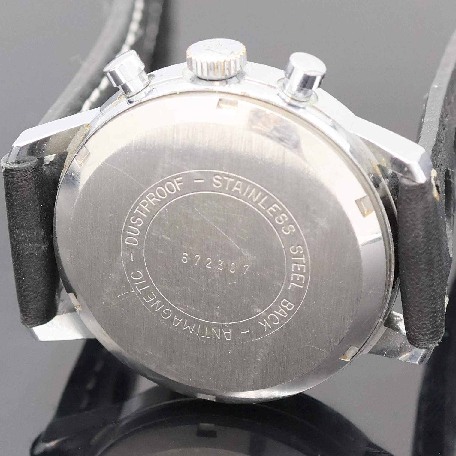 Detail e: DUGENA Herrenarmbanduhr mit Chronograph, Handaufzug, Schweiz um 1970, verchr. Geh. m. verschr. Stahlboden, schwarzes Zifferbl. m. arab. Std., silb. ...
