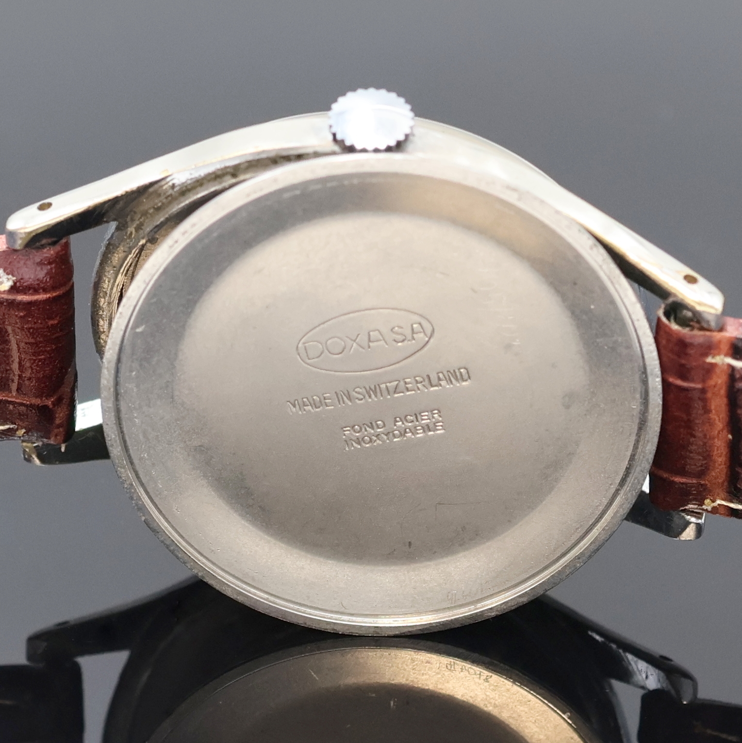 Detail d: DOXA große Armbanduhr in Stahl, Schweiz um 1965, Handaufzug, Boden aufgedr., silb. Zifferbl. m. gold. Std.-Ind. u. Zeigern, Kal. 1147, D. ca. 38 mm, ...