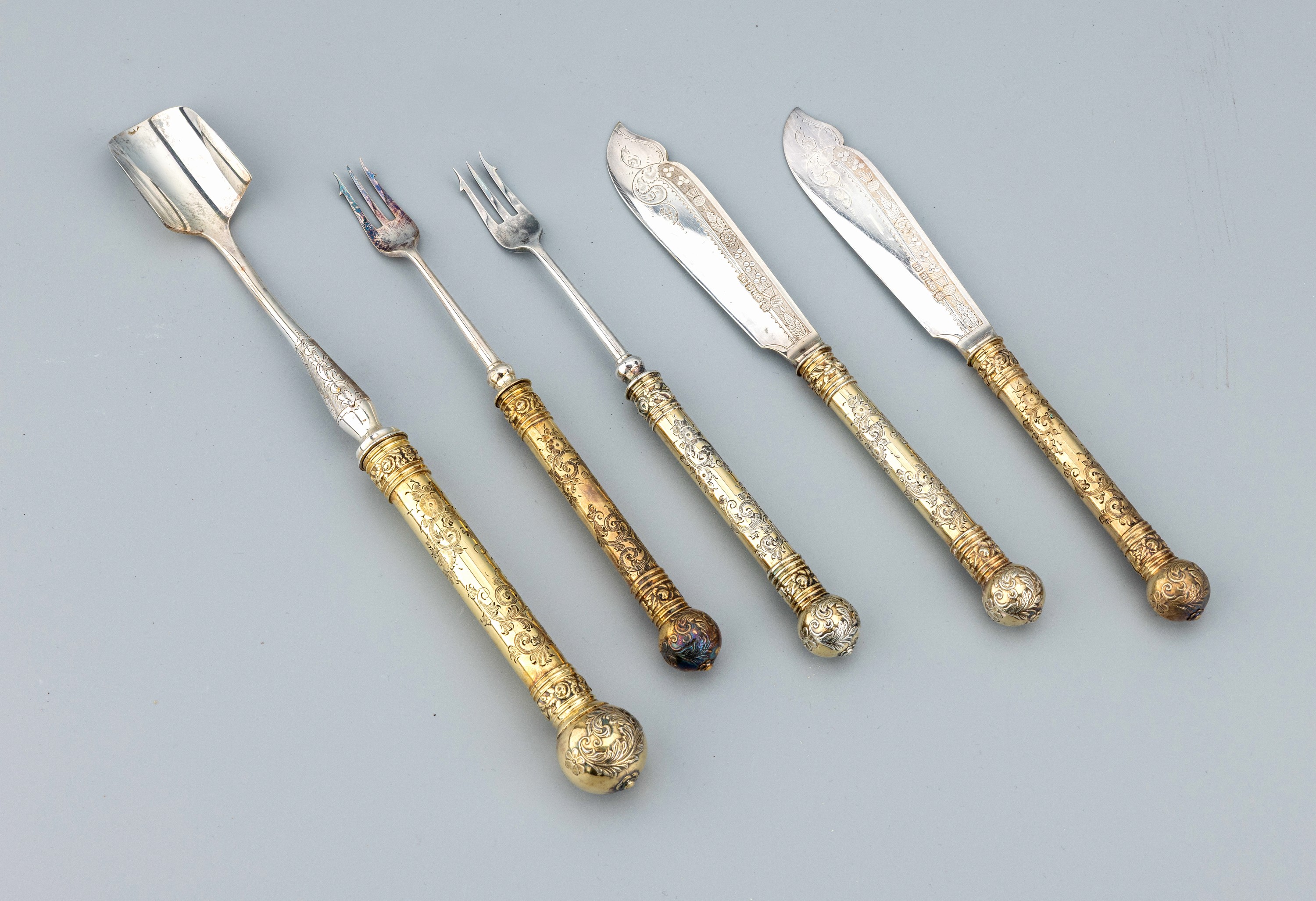 Detail a: 5-tlg. Käsebesteck, wohl England, um 1900, Metall versilbert und vergoldet, best. aus: 2 Messern, Klingen fein grav., 2 lange Käsegabeln, L. ca. ...