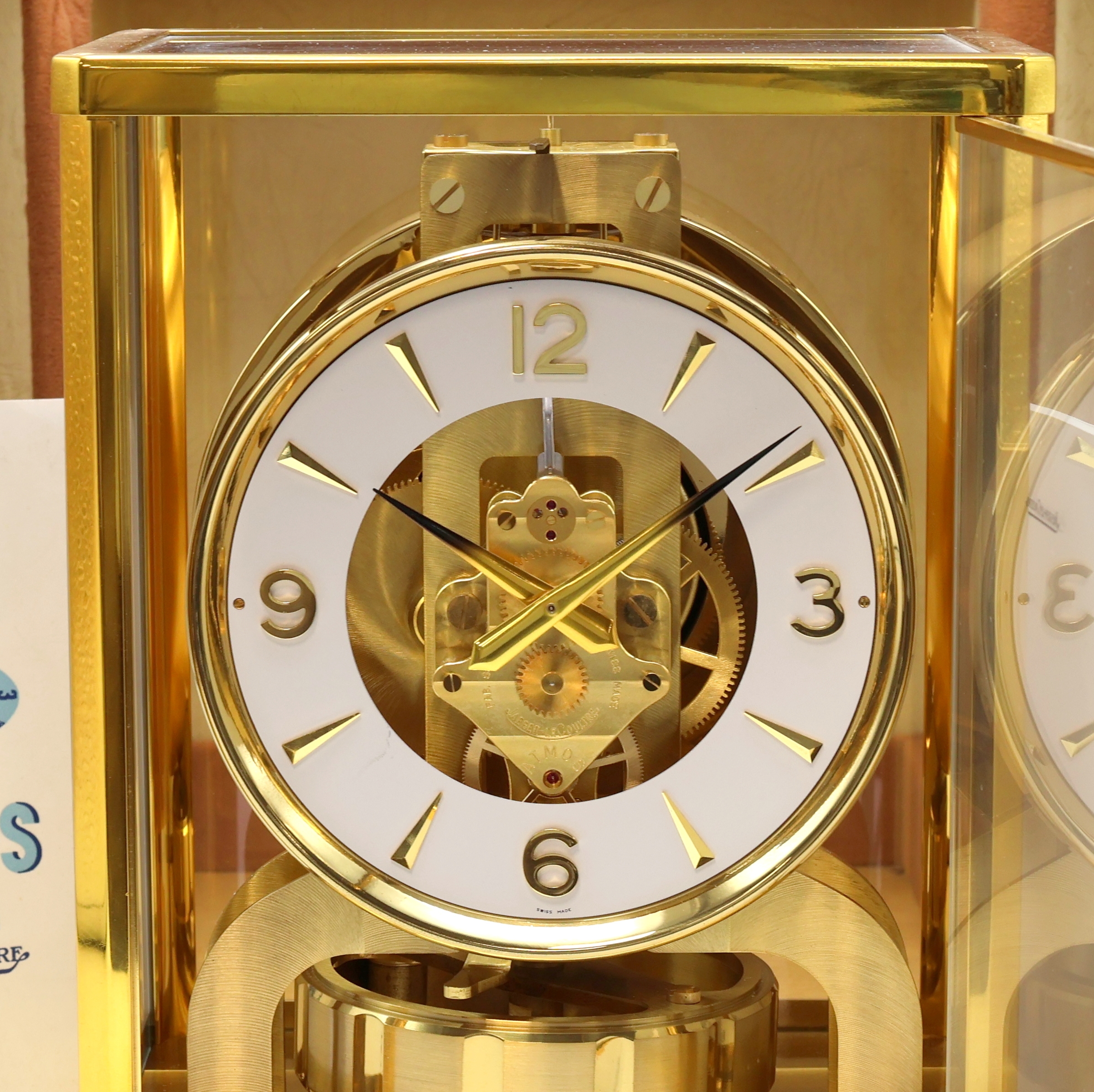 Detail a: Jaeger-LeCoultre Drehpendel-Tischuhr Atmos, Schweiz um 1965, verg., 5-seitig vergl. Geh., nach vorn zu öffnen durch Glastür, weißes ...