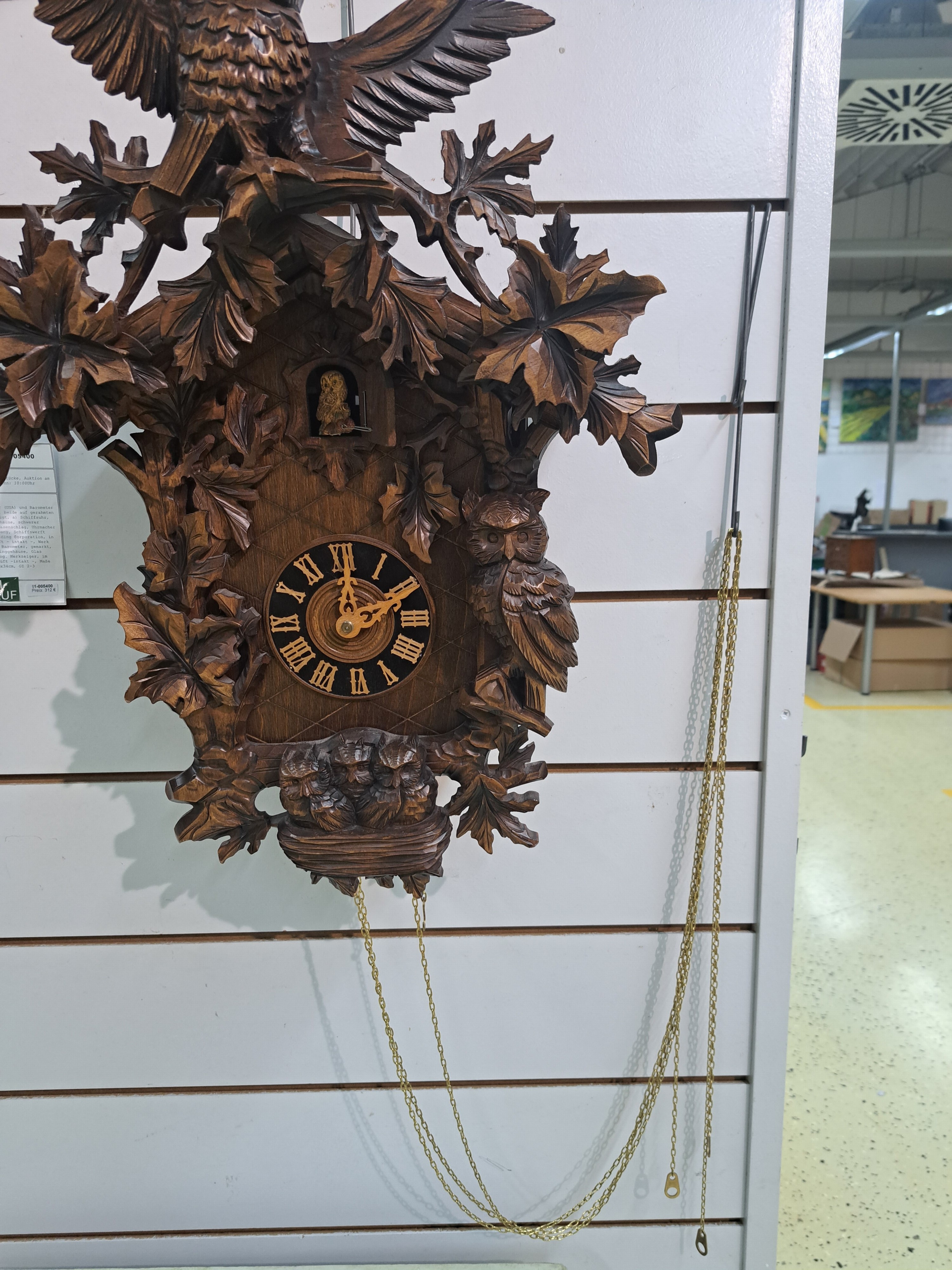 Detail f: Wanduhr mit Uhuruf und Musikspielwerk, Fa. Hönes, Titisee, um 1980, geschnitzte Front, mit plastischem Uhu und Blattwerk, orig. Aufsatz, seitliche ...
