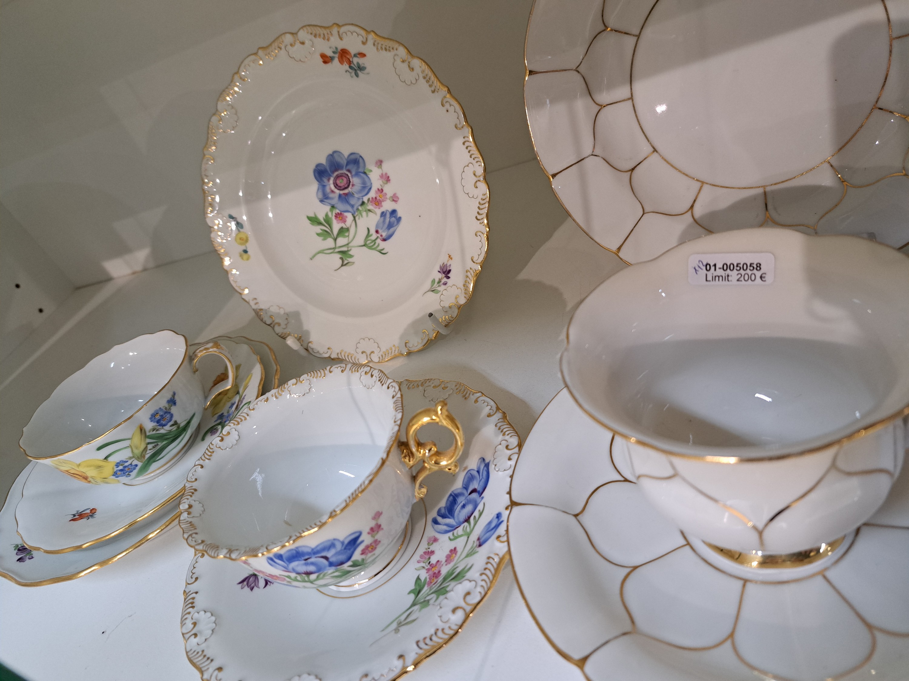 Detail b: 4 Kaffeegedecke, Meissen, 20. Jh., 1. Wahl, jeweils Tasse, Untertasse und Kuchenteller: 1x Indisch purpur goldgehöht, 1x Blume I mit gelber ...