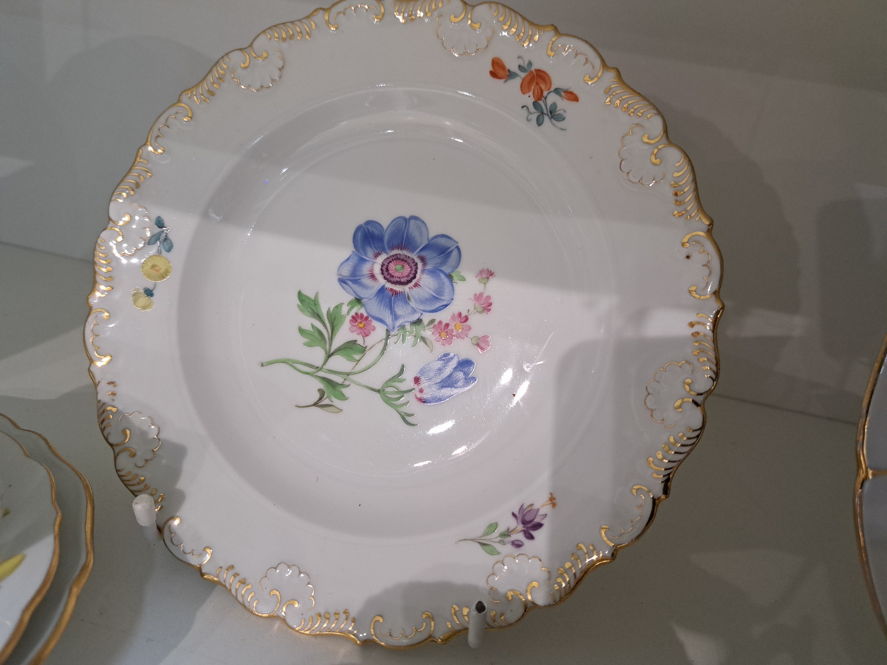 Detail c: 4 Kaffeegedecke, Meissen, 20. Jh., 1. Wahl, jeweils Tasse, Untertasse und Kuchenteller: 1x Indisch purpur goldgehöht, 1x Blume I mit gelber ...