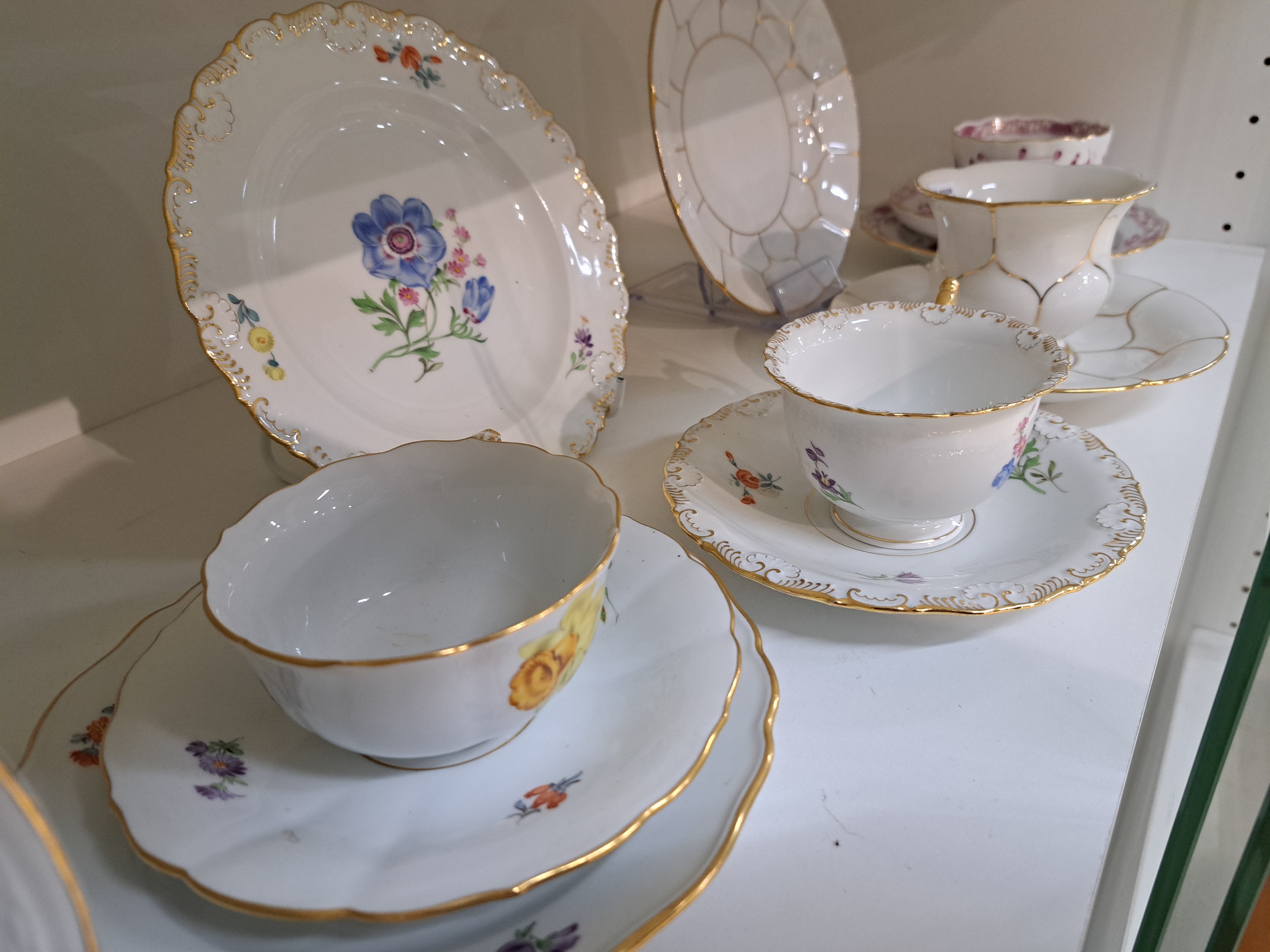 Detail d: 4 Kaffeegedecke, Meissen, 20. Jh., 1. Wahl, jeweils Tasse, Untertasse und Kuchenteller: 1x Indisch purpur goldgehöht, 1x Blume I mit gelber ...
