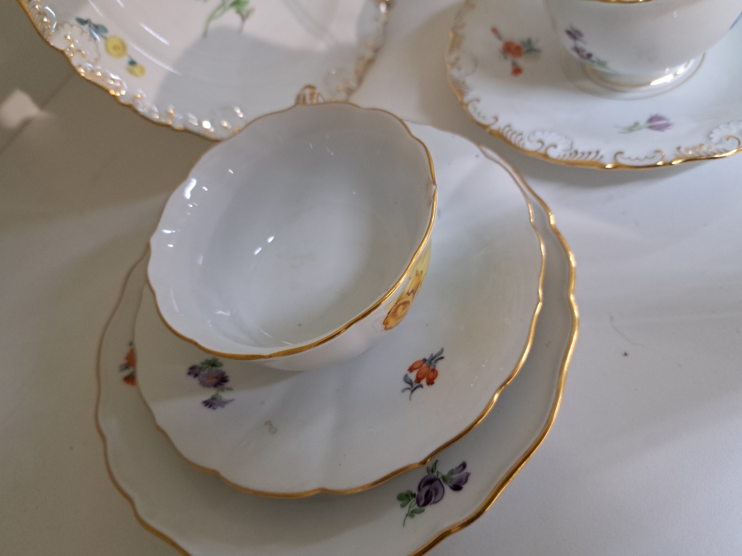 Detail e: 4 Kaffeegedecke, Meissen, 20. Jh., 1. Wahl, jeweils Tasse, Untertasse und Kuchenteller: 1x Indisch purpur goldgehöht, 1x Blume I mit gelber ...