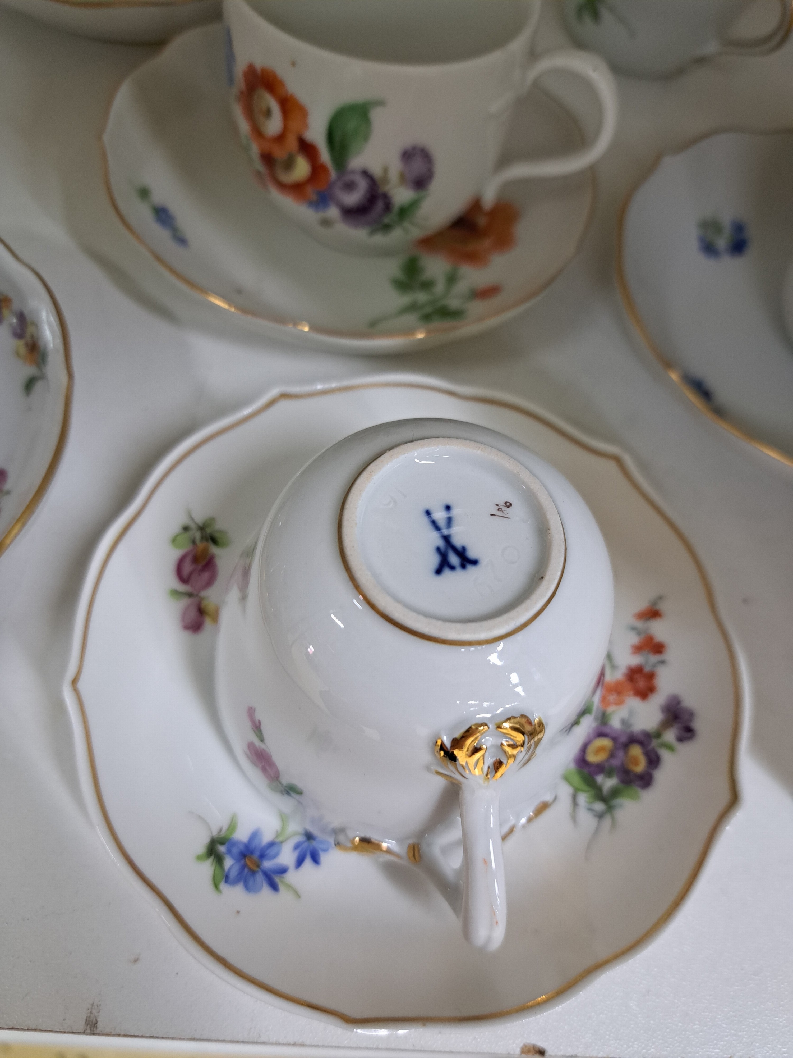 Detail e: 10 Mokkatassen mit 8 Untertassen, Meissen, 20. Jh., darunter gelbe Rose, rote Rose, gestreute Blumen, Blume I, Goldränder