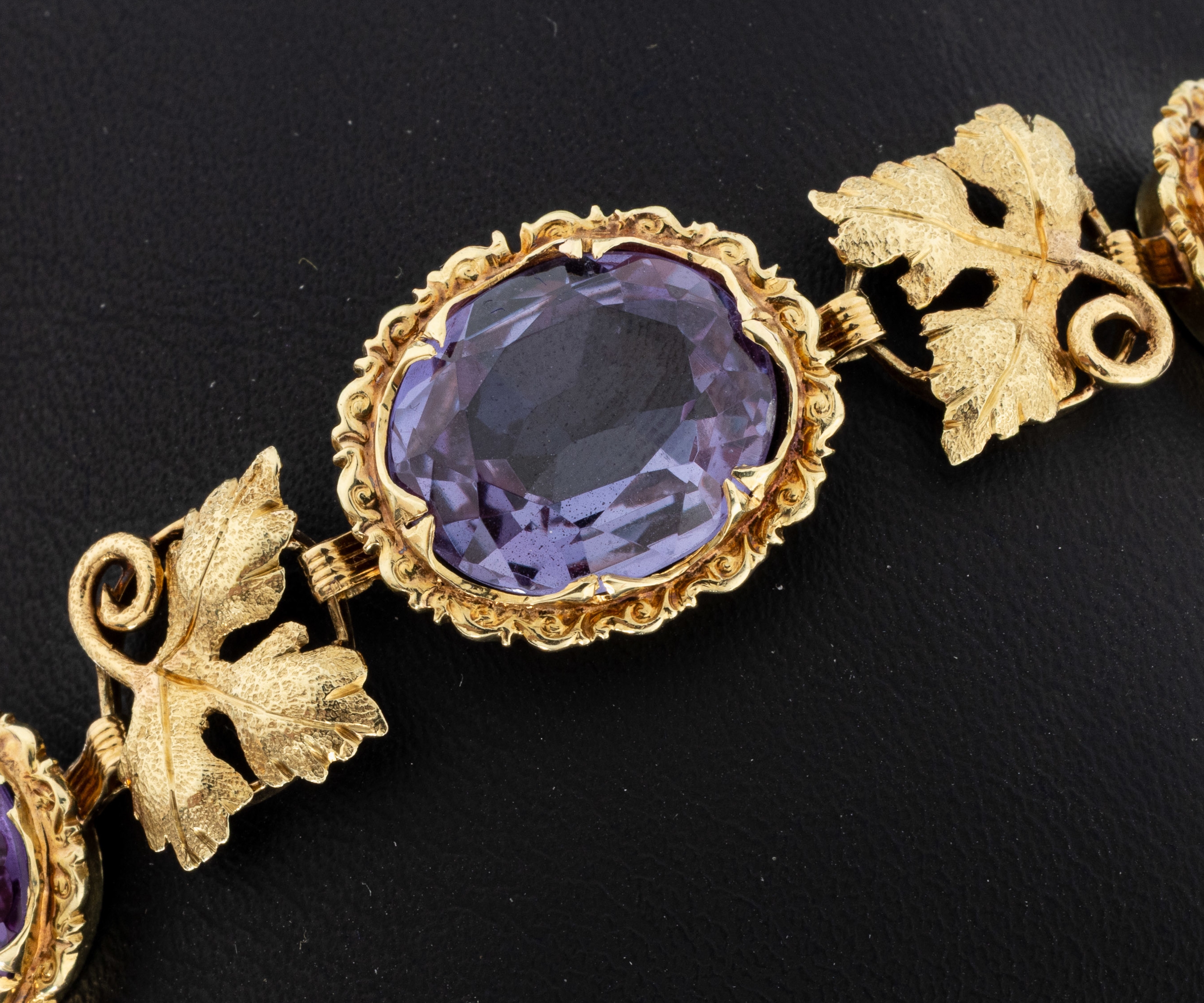 Detail b: 14 kt Gold Farbstein-Armband, 1960er Jahre, GG 585/000, 5 ovalfacett. synth. Korunde, Zwischenglieder mit Weinlaubdekor, L. ca. 18 cm, Kastenschloss ...