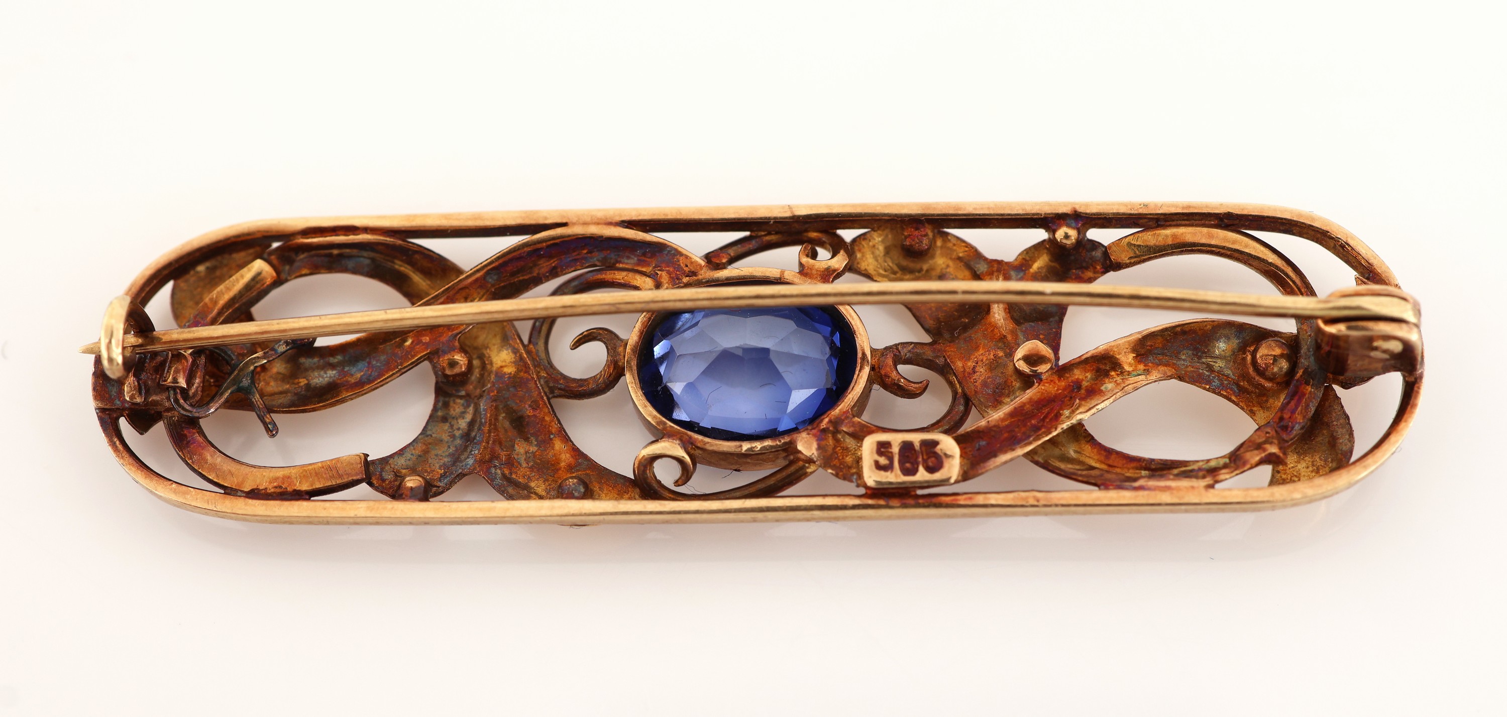 Detail c: 14 kt Gold Saphir-Brosche, um 1930, GG 585/000, ovale Grundform, abstrakt floral, durchbrochen, mittig ovalfacett. Saphir ca. 2.0 ct, L. ca. 5.2 cm, ...
