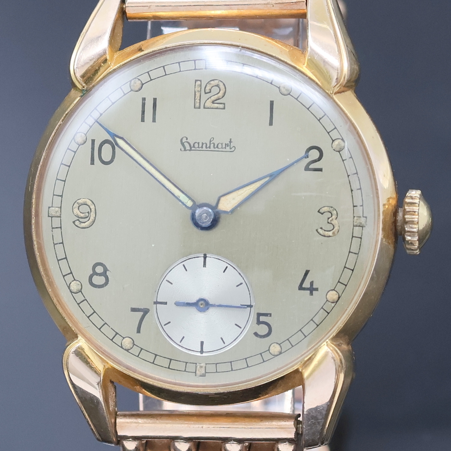 Detail a: HANHART rot-vergoldete Herrenarmbanduhr, Deutschland um 1940, Handaufzug, 2-tlg. Geh., Stahlboden aufgedr., zeitident. rotverg. Gliederband, silb. ...