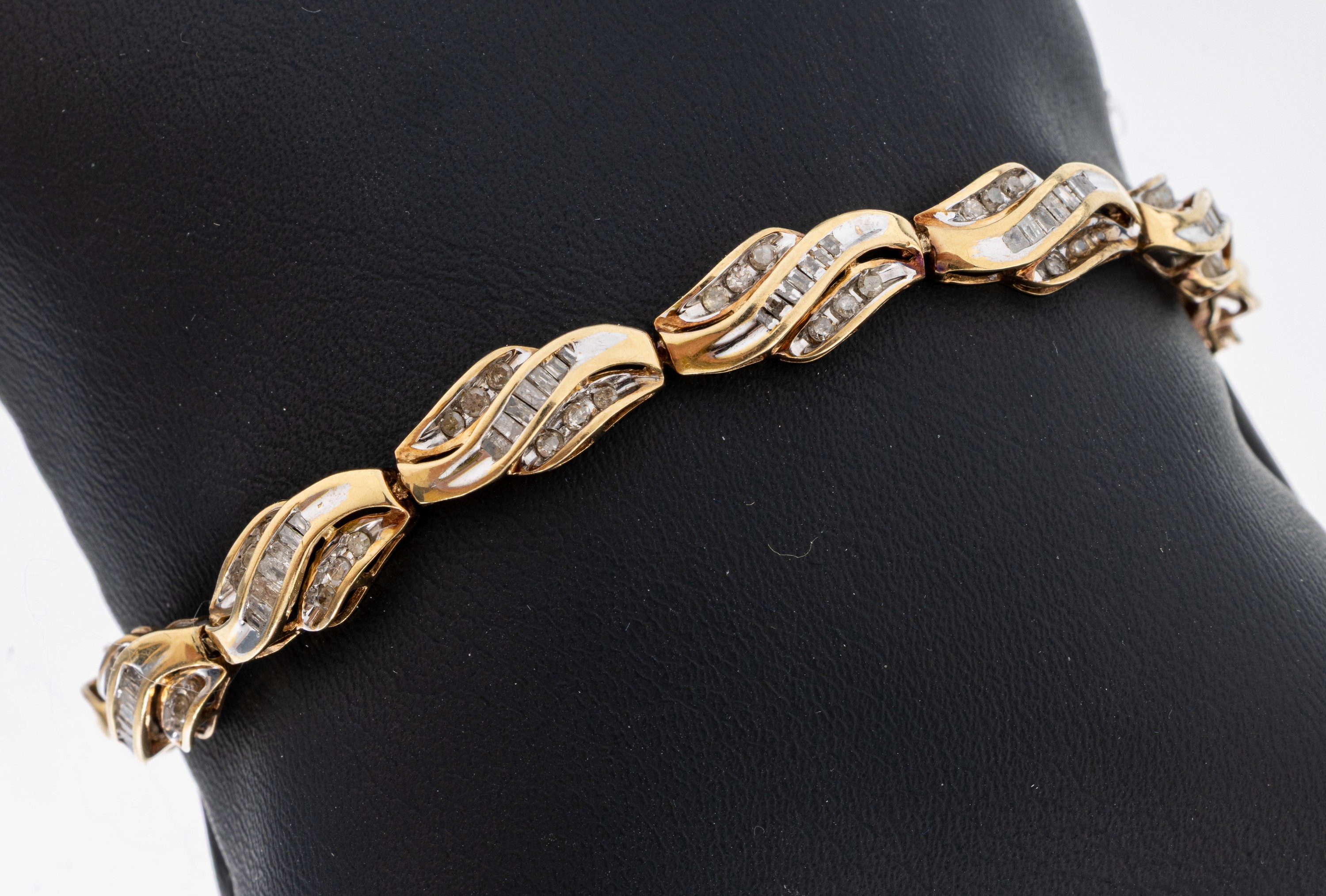 10 kt Gold Diamant-Armband, GG 417/000, geschwungene Glieder, 84 Diamantbaguettes 72 Brillanten und 8/8-Diamanten zus. ca. 1.0 ct Weiß/p, L. ca. ...