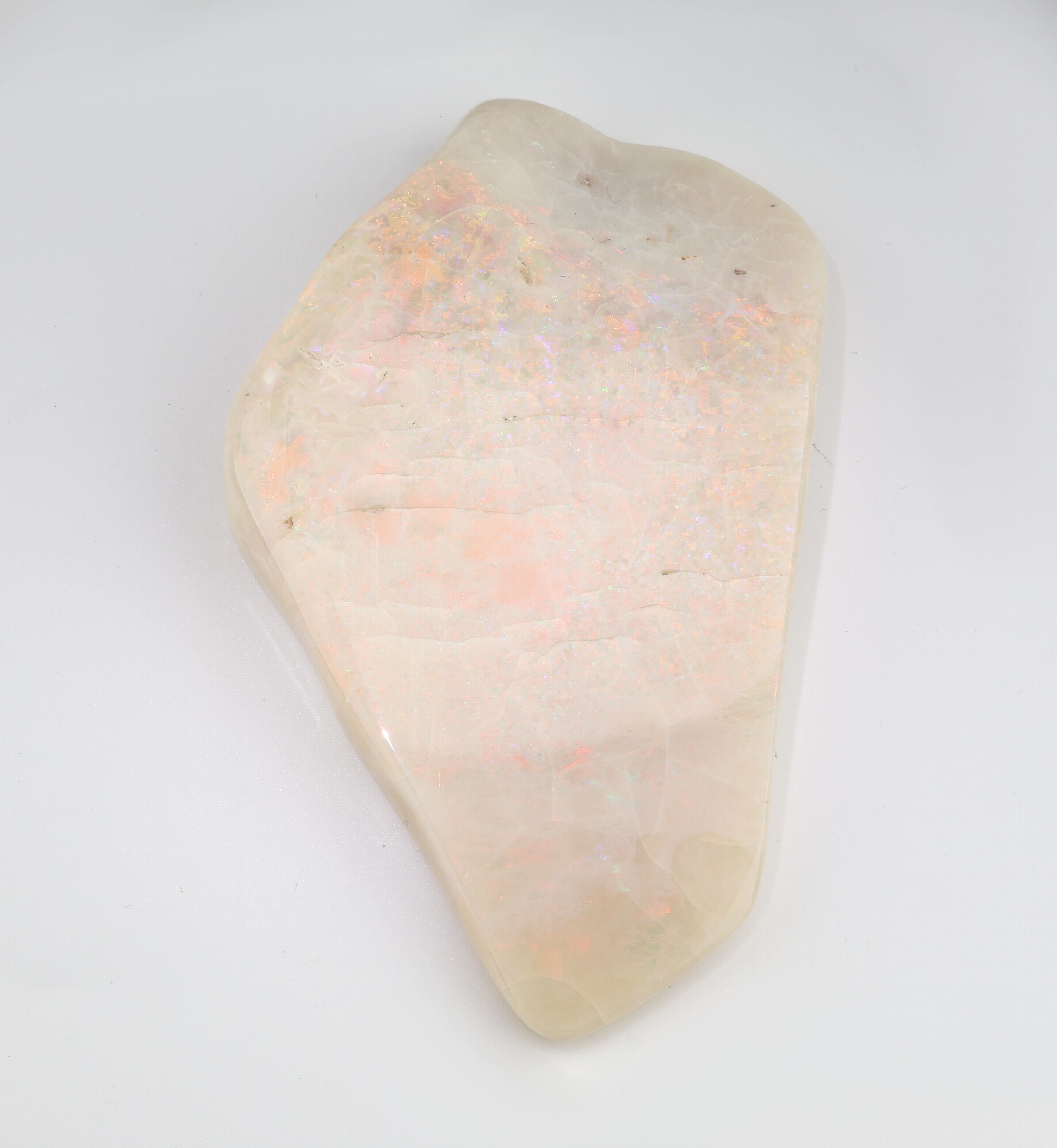 Detail a: Opal-Briefbeschwerer, Vollopal, ca. 739.55 ct, Farbspiel in Rot, Gelb, Grün und Blau, ca.11.5 x 7 cm, stark trockenrissig