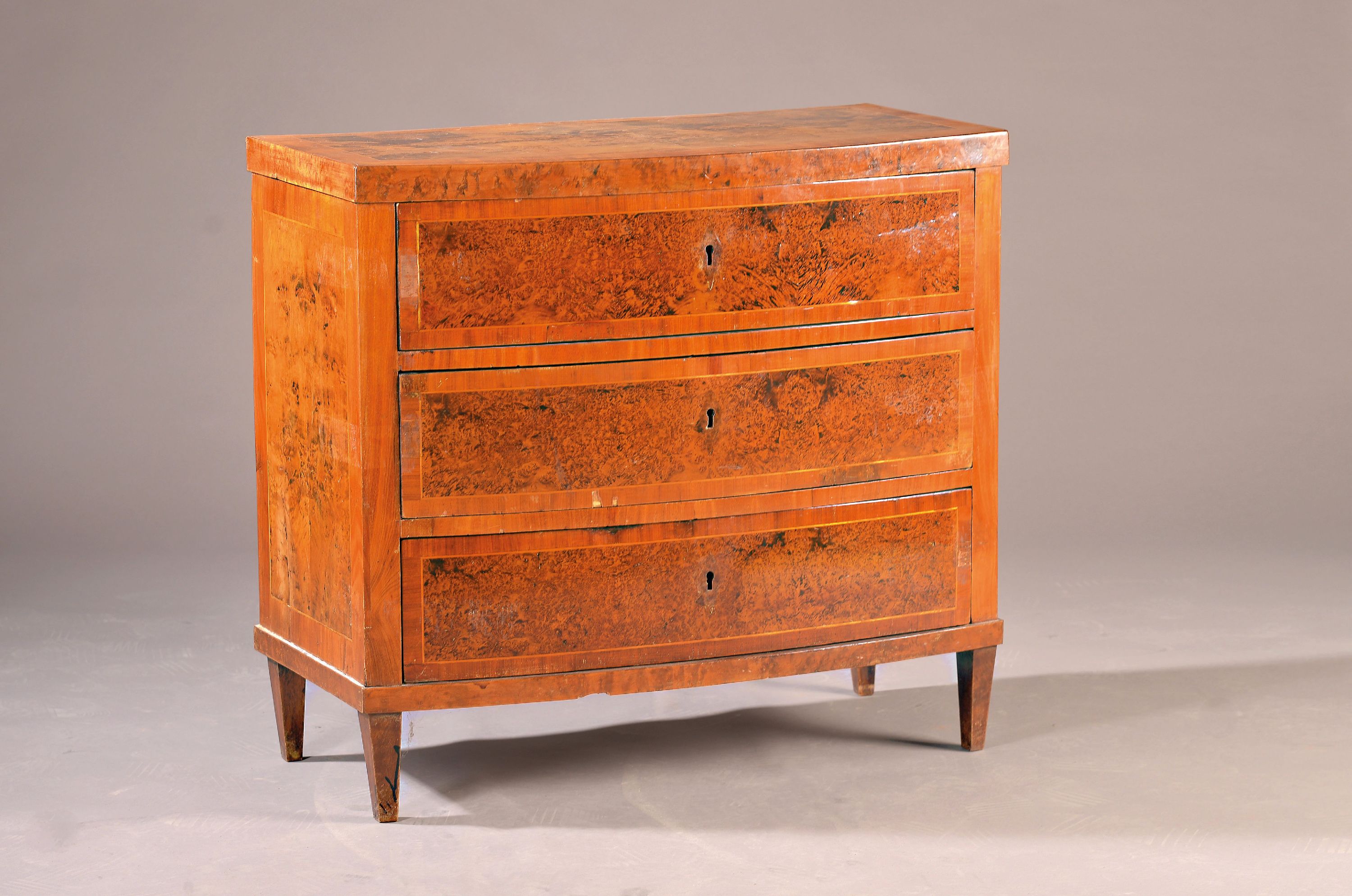 Detail a: Bowfrontkommode des Biedermeier, deutsch, um 1840, Nußbaumfurnier, Fadenintarsien, z.T. Wurzelnußfurnier, Bowfront, 3-schübig, 82x90x45 cm, ein ...