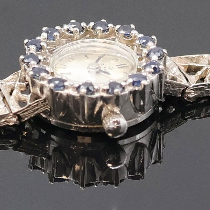 Detail d: TISSOT Damenarmbanduhr in WG 585/000 mit Saphiren, Schweiz 1970er Jahre, Handaufzug, orig. Goldband, Lünette m. Saphiren bes., Boden aufgedr., silb. ...
