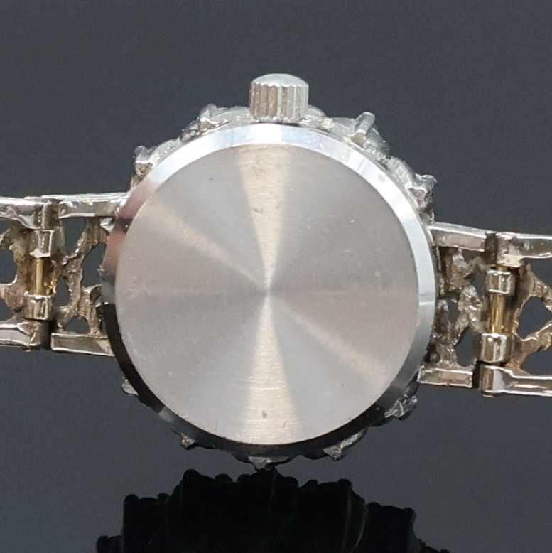 Detail e: TISSOT Damenarmbanduhr in WG 585/000 mit Saphiren, Schweiz 1970er Jahre, Handaufzug, orig. Goldband, Lünette m. Saphiren bes., Boden aufgedr., silb. ...