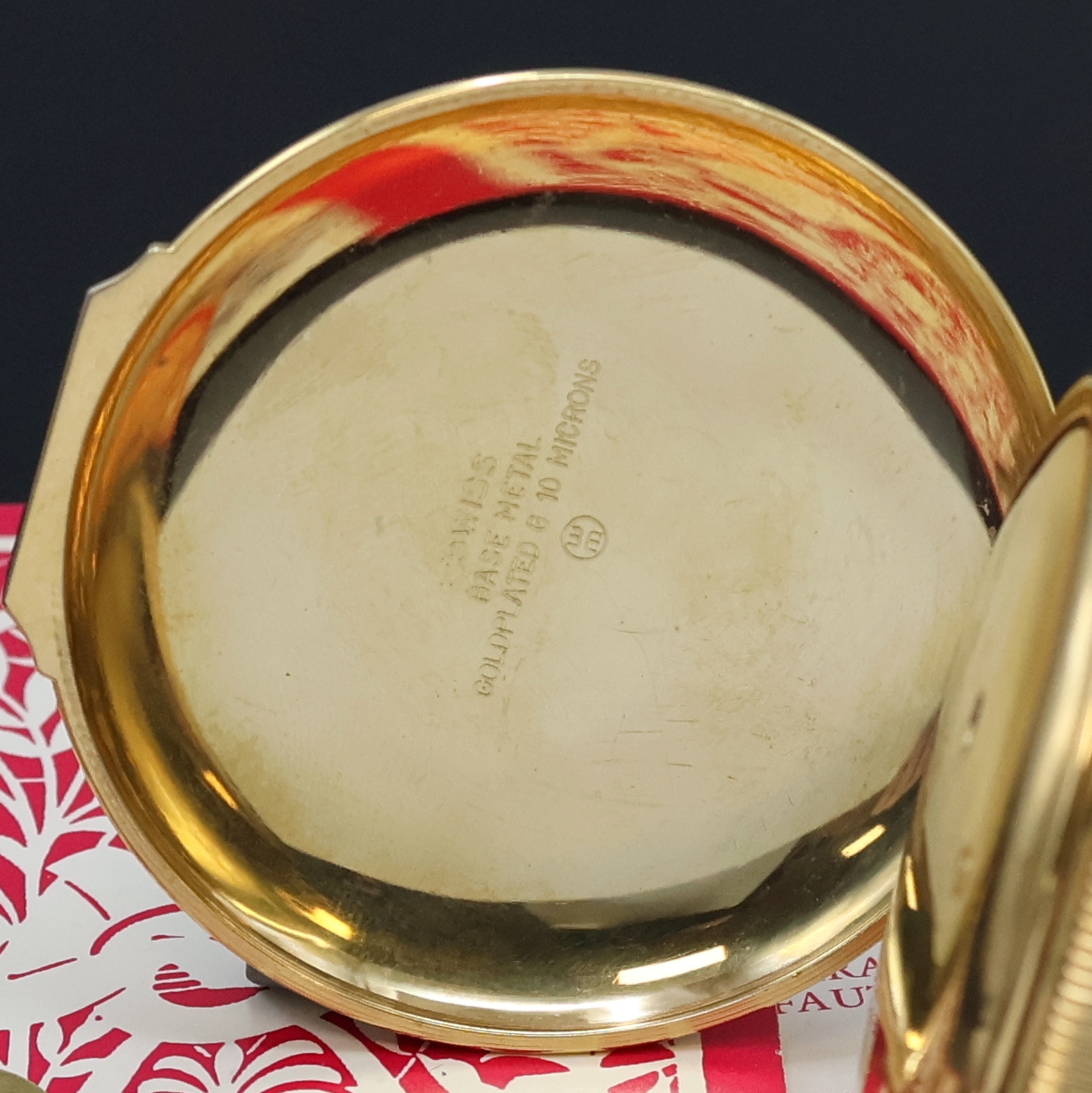 Detail b: REUGE Taschenuhr mit Wecker-Spieluhr und Figurenautomat, Schweiz verk. lt. beil. Pap. 08/1980, verg. Geh., Rückdeckel m. grav. Musikinstrumenten, ...