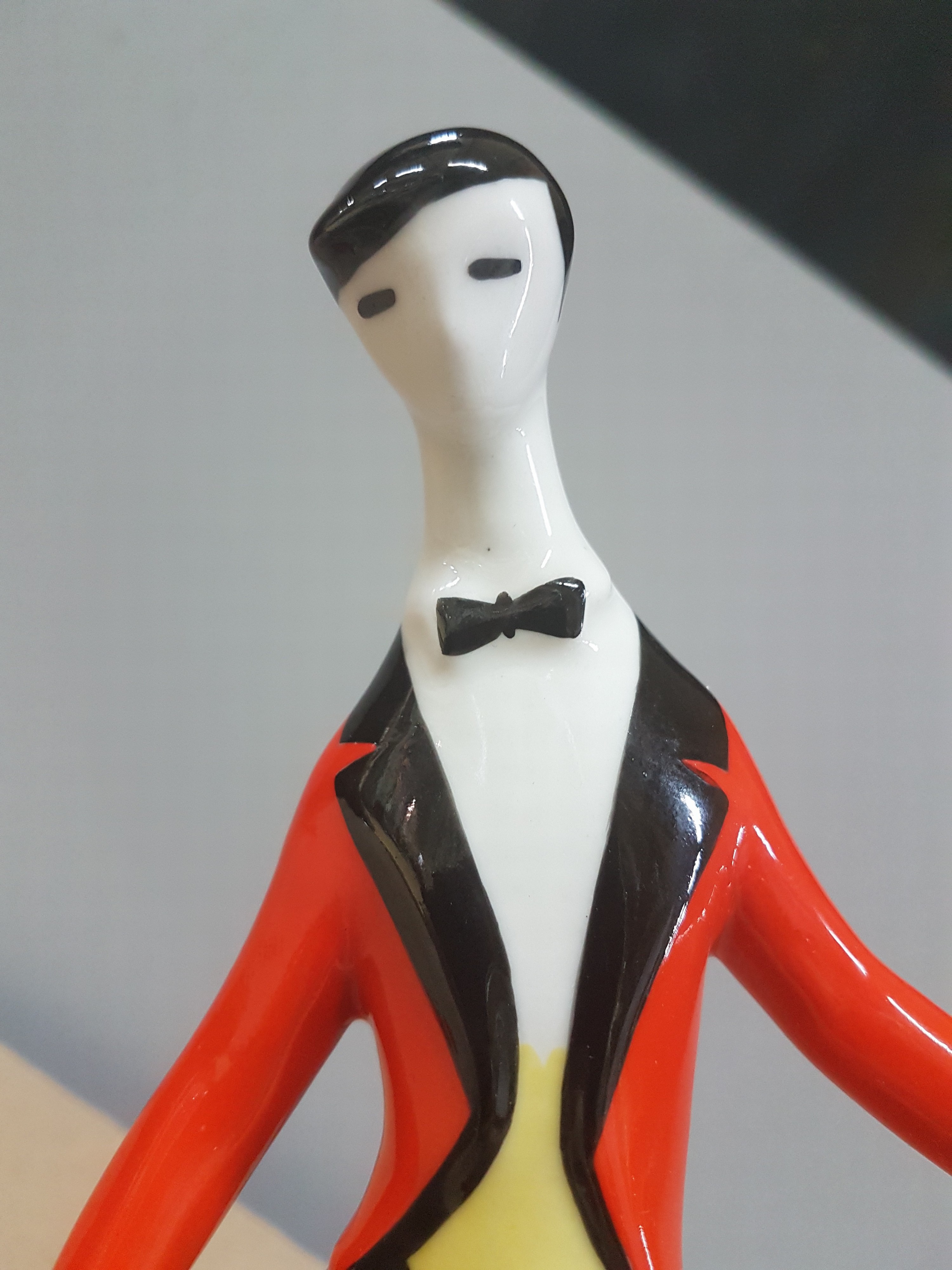 Detail e: Porzellanfigur, Zsolnay Pecs Ungarn, Entwurf Janos Török (1932-1996), Cellospieler im roten Frack, bunt bemalt, H. ca. 21.5cm
