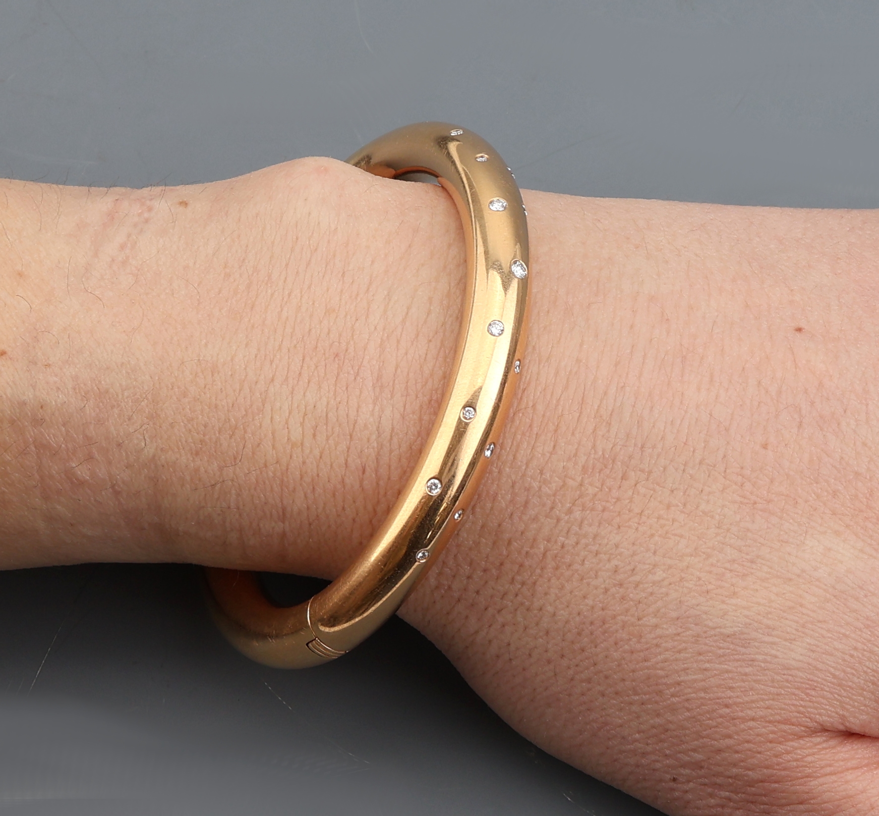 Detail c: 18 kt Gold Brillant-Armreif, GG 750/000, 15 Brillanten zus. ca. 0.22 ct Weiß/si, Klappscharnier, ca. 6.5 x 5.5 cm, ca. 54.6 g, Meistermarke Emil ...