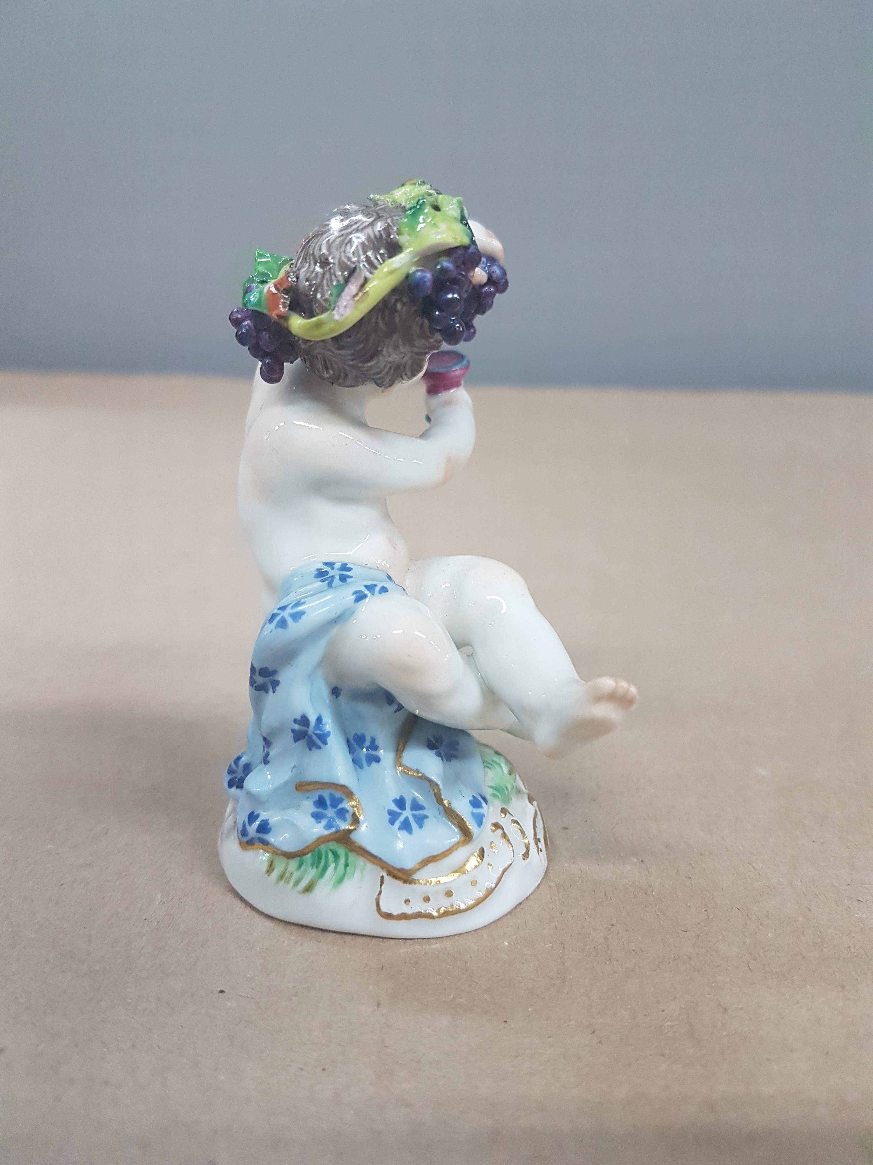 Detail d: Porzellanfigur, Meissen, um 1900, kleiner Bacchus, polychrom bemalt, Goldstaffage, H. 8cm, am Haarkranz l. best