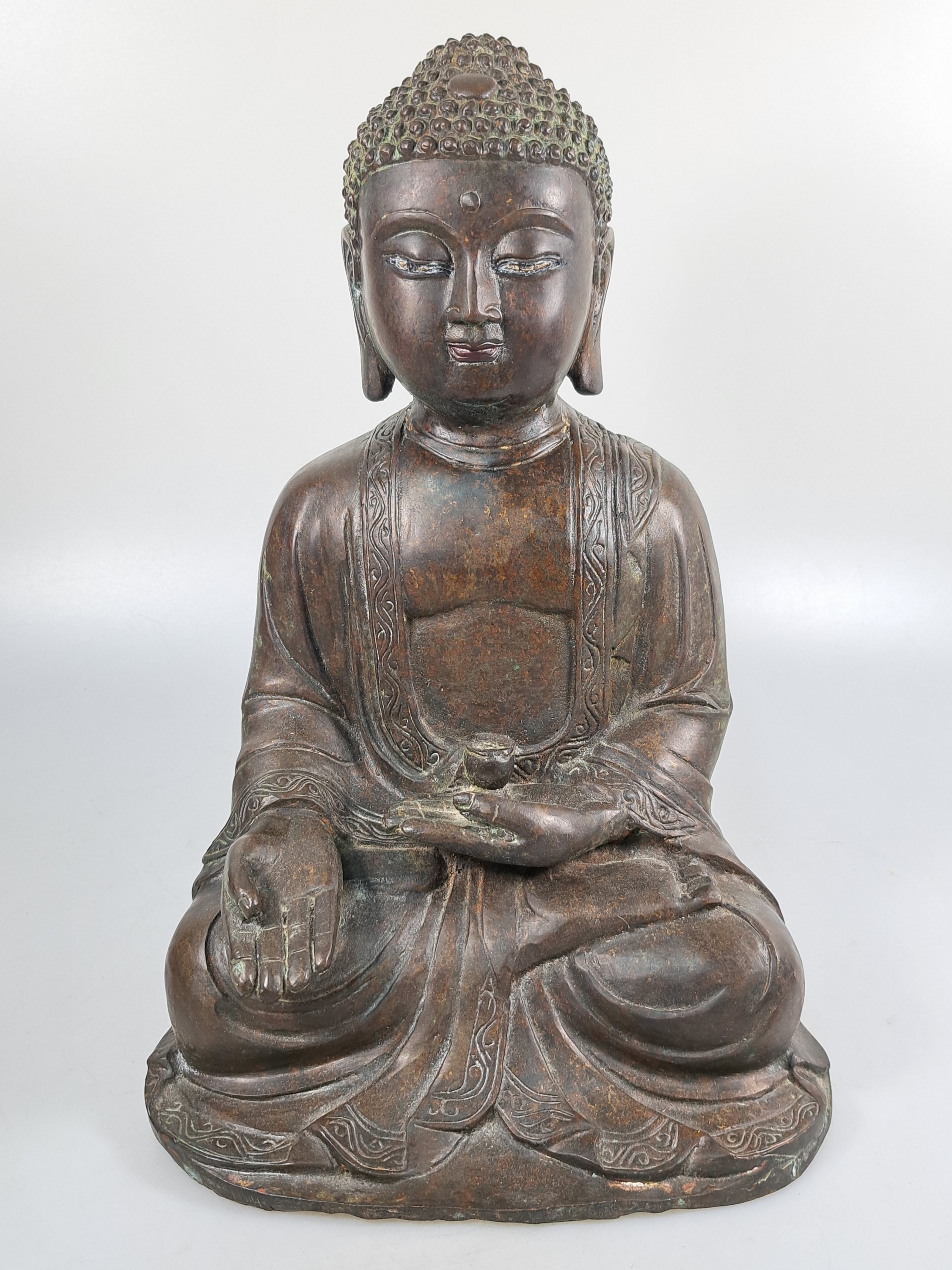 Detail a: Buddha/Shakyamuni, wohl Ming-Dynastie 17. Jh., dunkel patiniert, unten geschlossen, Gewand mit stiltyp. Faltenwurf und Randbordüre, Altersspuren, ...