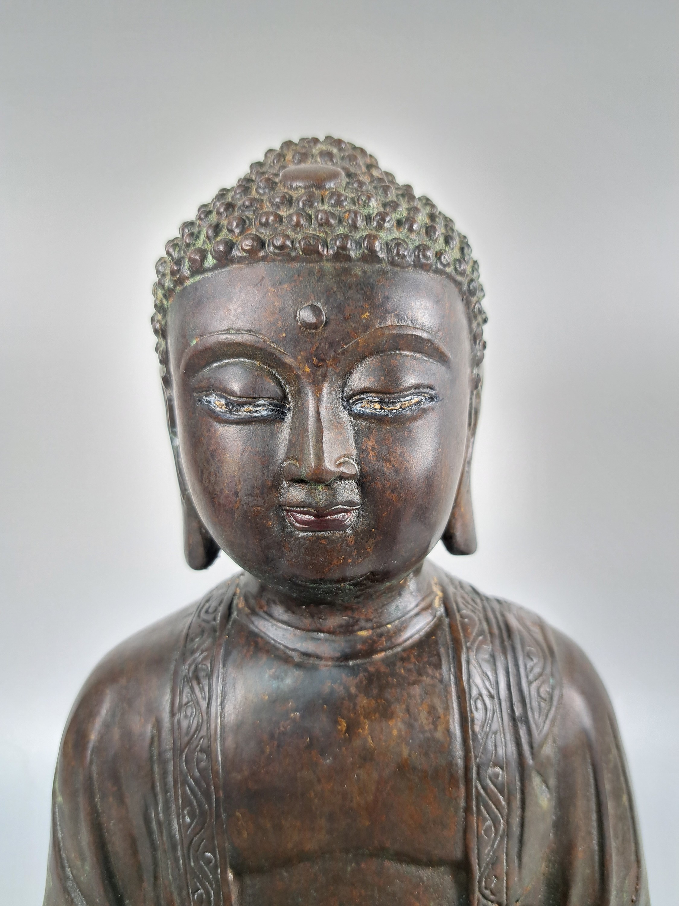 Detail b: Buddha/Shakyamuni, wohl Ming-Dynastie 17. Jh., dunkel patiniert, unten geschlossen, Gewand mit stiltyp. Faltenwurf und Randbordüre, Altersspuren, ...