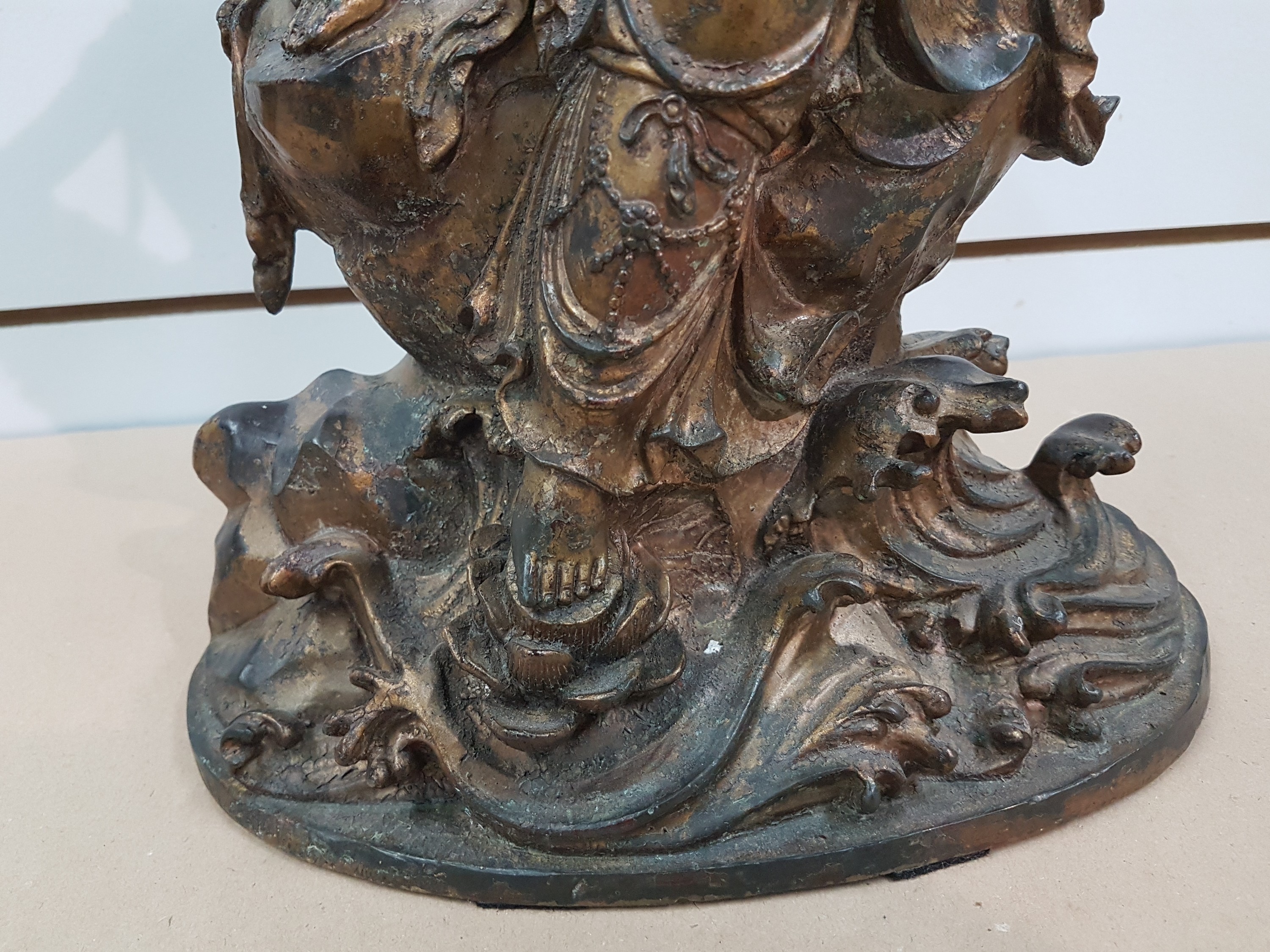 Detail e: Große Guanyin/Guan Yin, China, wohl um 1900, Bronze, auf erhöhtem Felsvorsprung sitzende Gottheit, ein Fuß auf einer Lotusblüte platziert, das ...