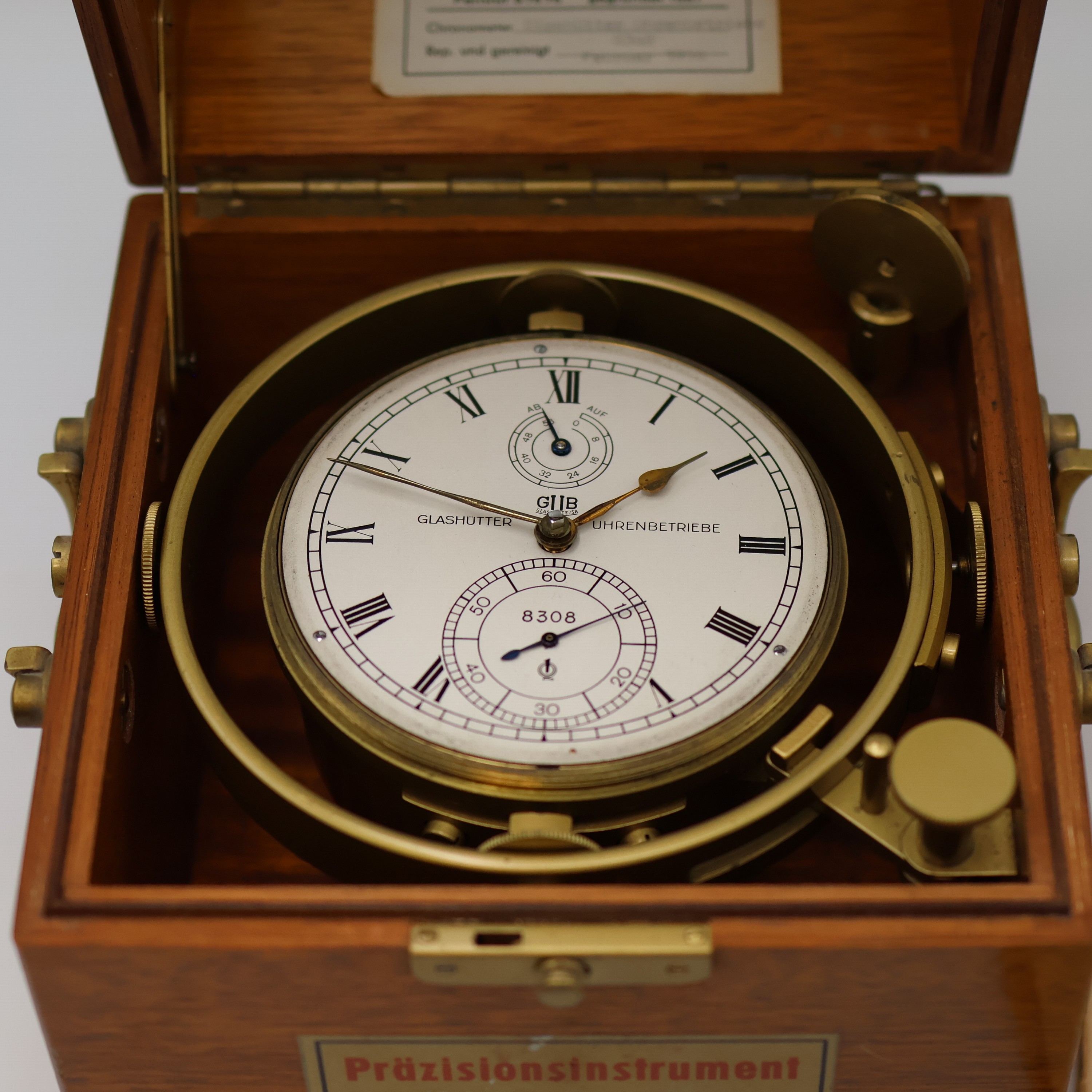 Detail c: GUB Marinechronometer Nr. 8308 mit Chronometer-Tagebuch der MS "Ledingerland", DDR um 1964, facett-vergl. 2-tlg. Holzkasten, kardanisch ...