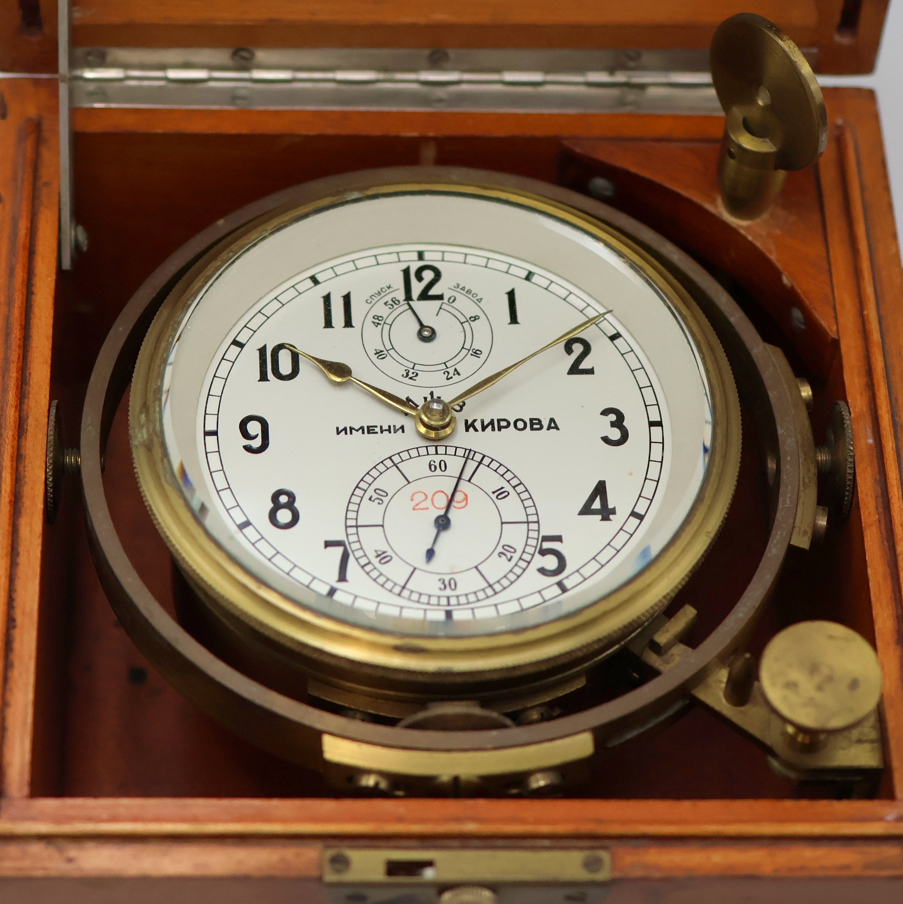 Detail a: 1. Moskauer Uhrenfabrik Nummer 209 frühes Marinechronometer, UDSSR um 1952, 3-tlg. Holzkasten, seitl. Tragegriffe, kardanisch aufgehängtes ...
