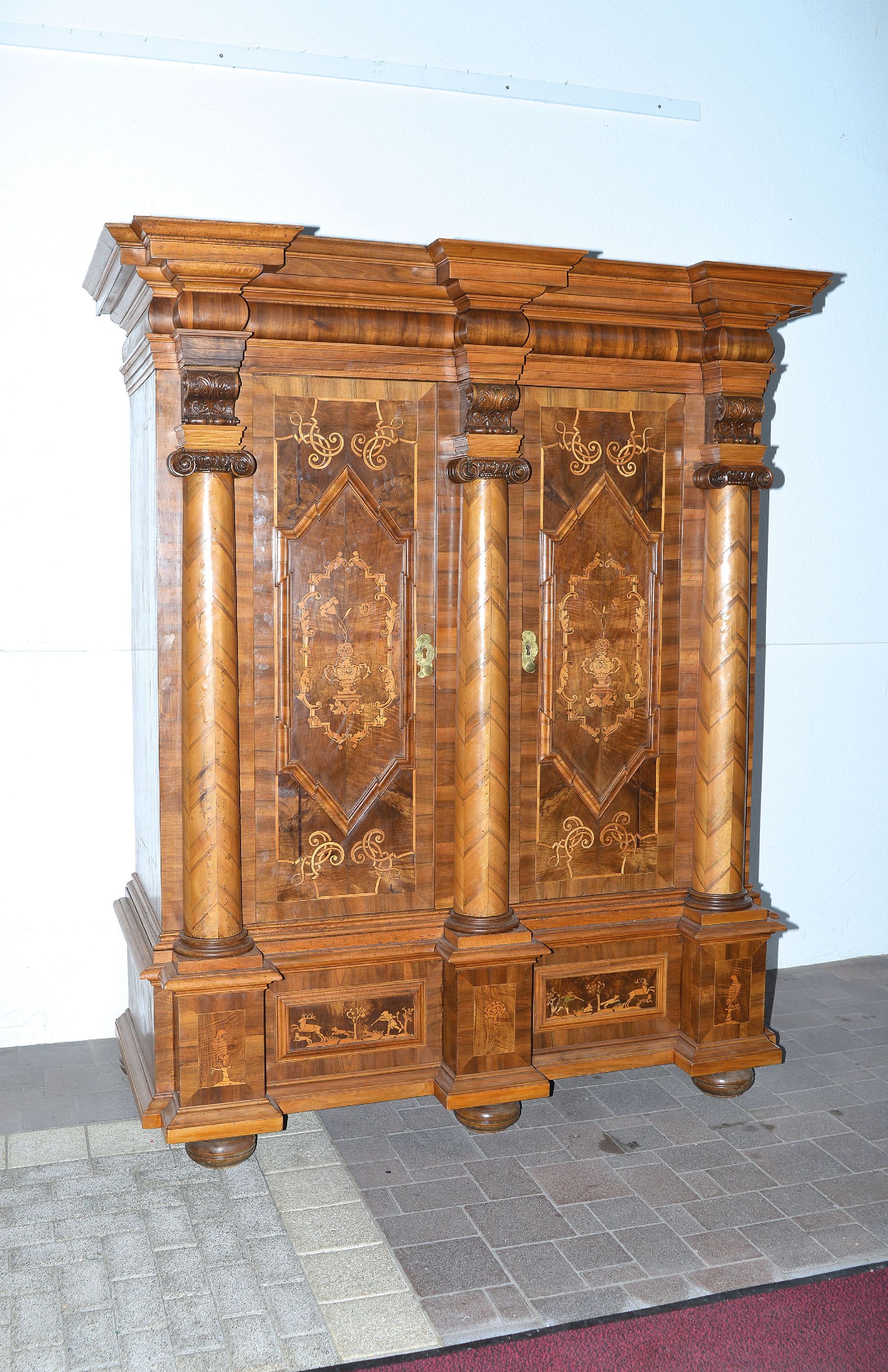 Detail a: Barocker Prunk- bzw. Dielenschrank, Augsburg, um 1720, Nussbaum furniert, Marketerie mit Bandelwerk, Akanthusranken u. Rollwerk, Unterteil mit ...
