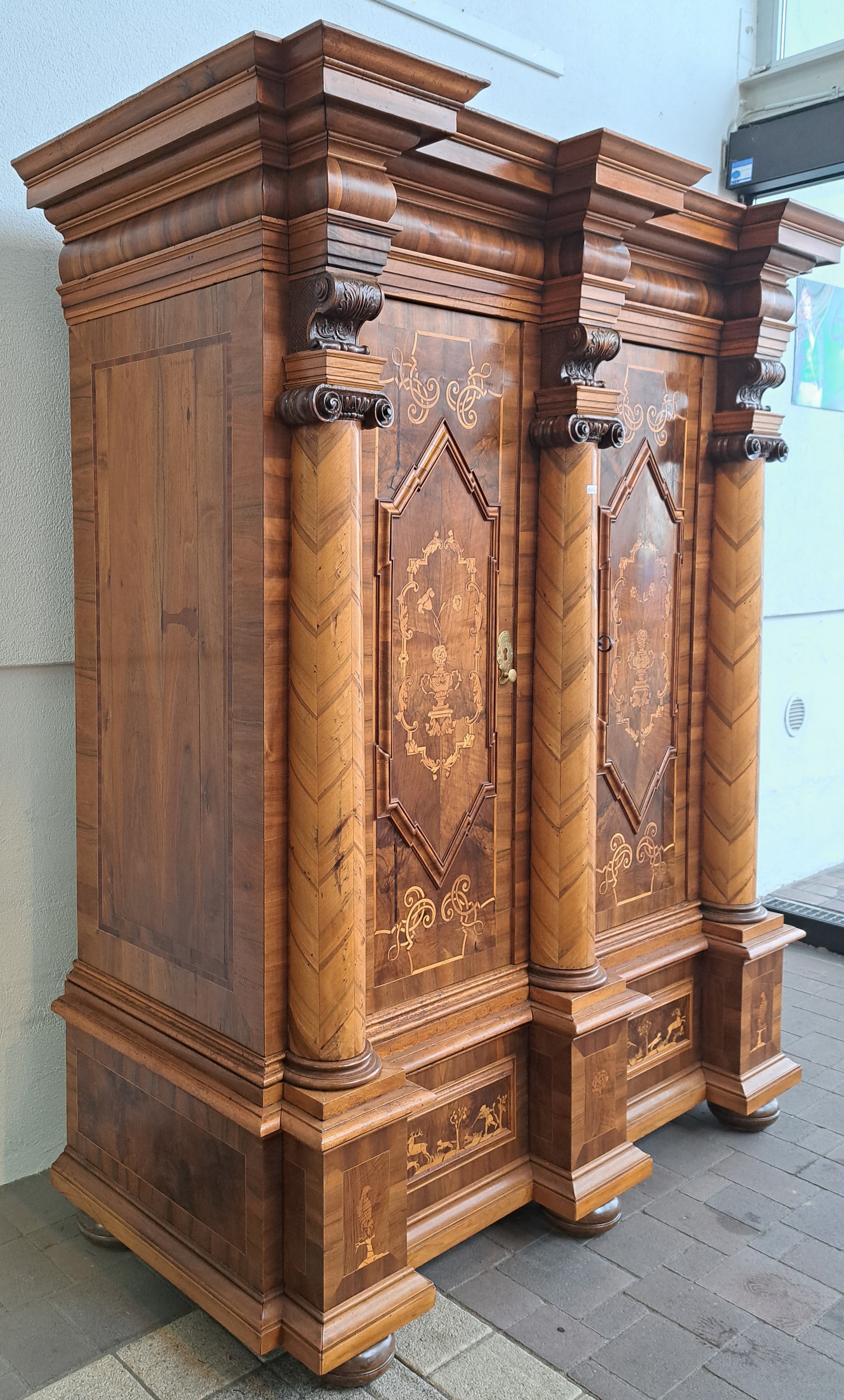 Detail g: Barocker Prunk- bzw. Dielenschrank, Augsburg, um 1720, Nussbaum furniert, Marketerie mit Bandelwerk, Akanthusranken u. Rollwerk, Unterteil mit ...