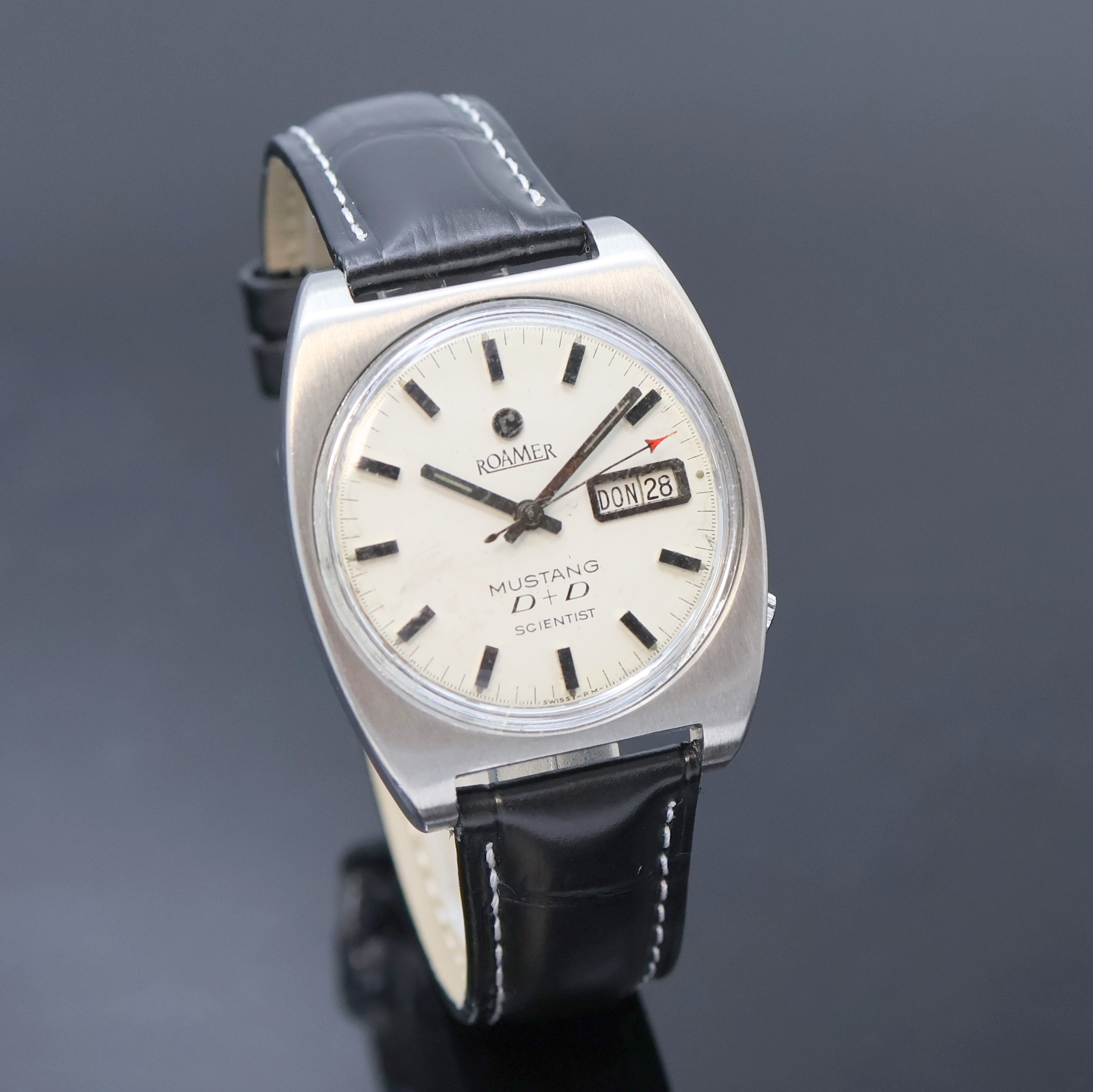Detail b: ROAMER Mustang D + D Scientist Herrenarmbanduhr Referenz 478-1120.601, Schweiz um 1970, Automatik, Edelstahl Monocoque-Geh., weißes Zifferbl. m. ...