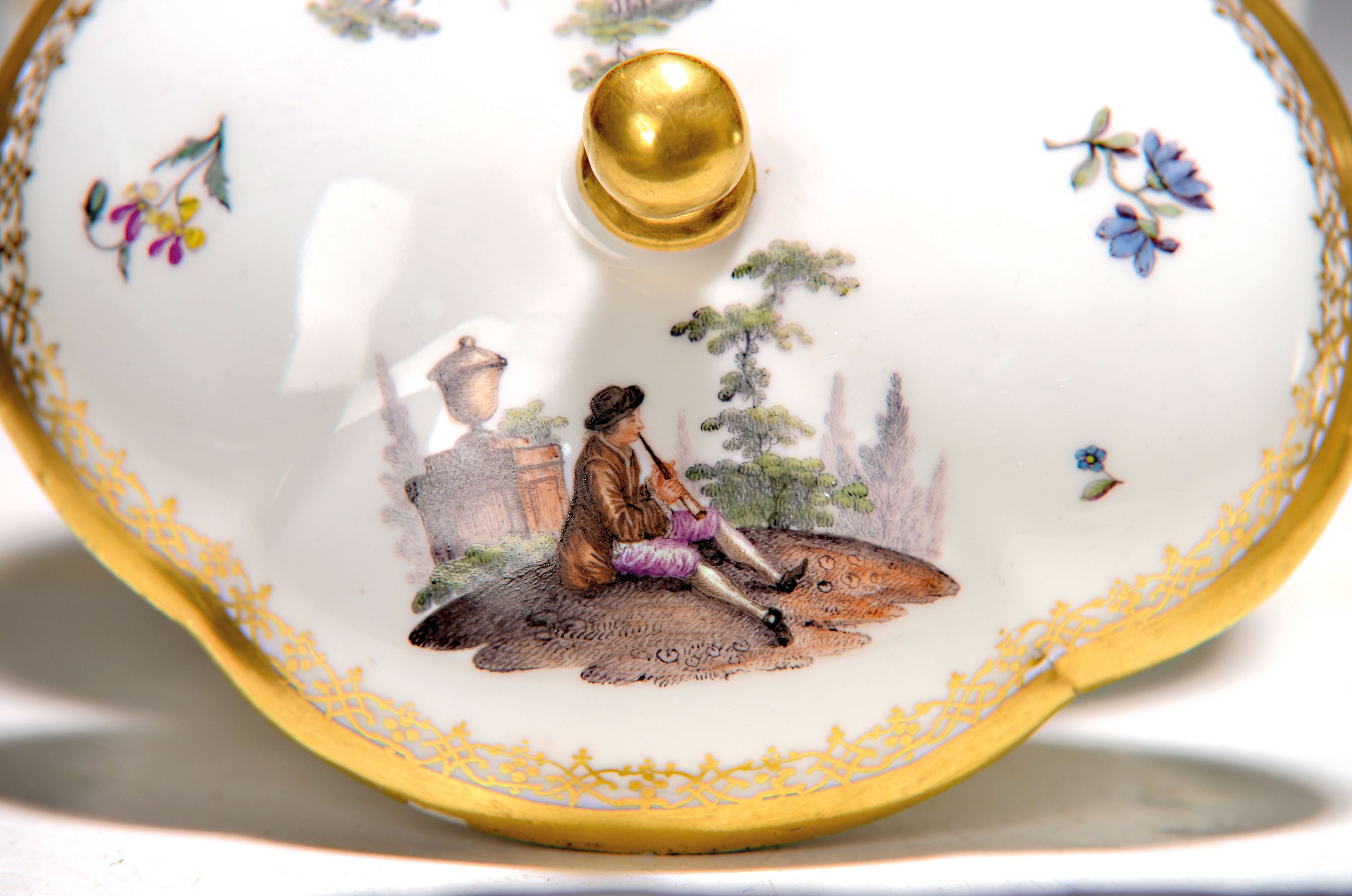 Detail b: Deckeldose, Meissen, um 1750, Porzellan, beidseitig mit galanten Szenen bemalt, auf dem Deckel Kavalier und Dame, reicher Goldspitzendekor, leicht ...