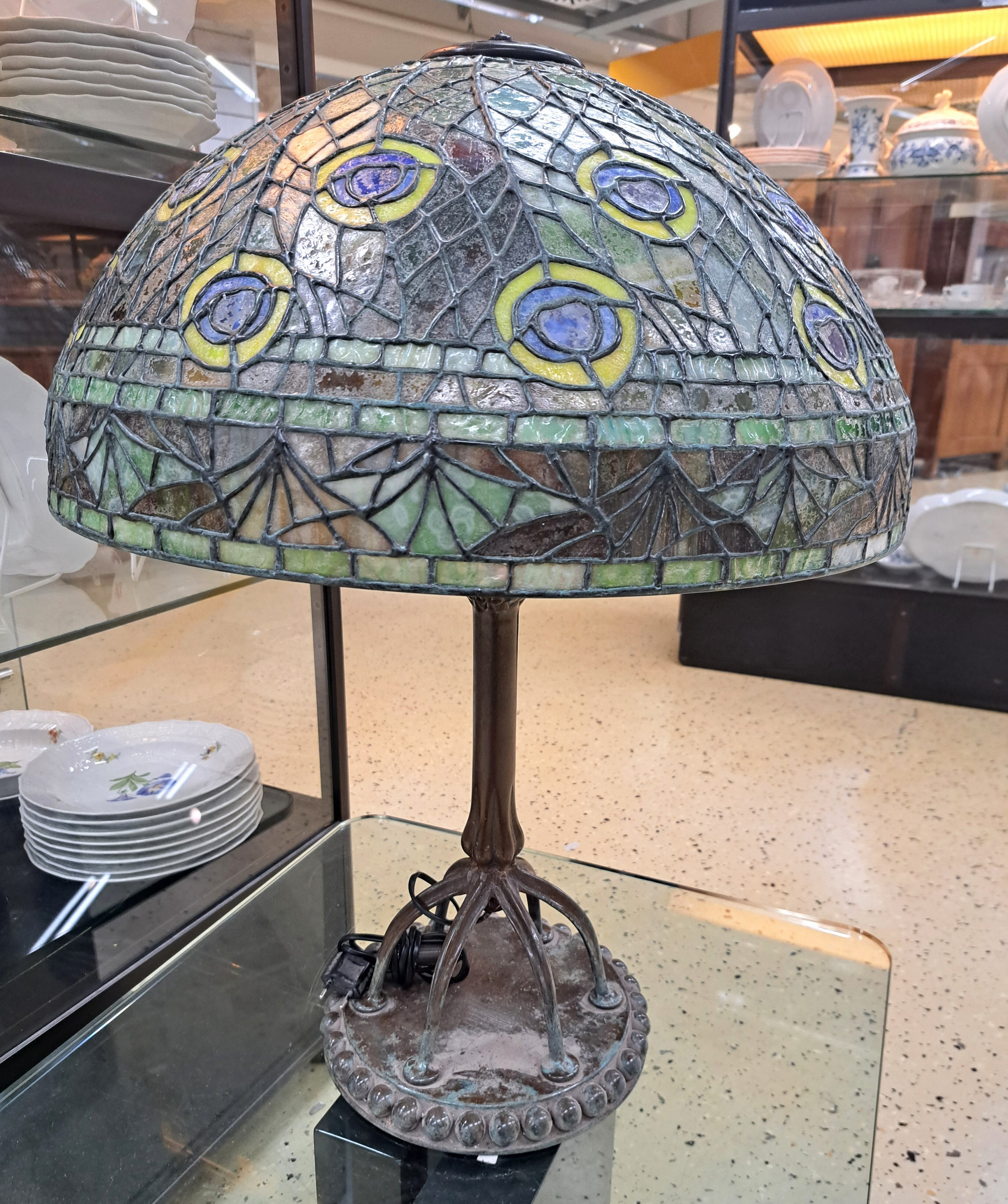 Detail b: Tiffany-Stil-Lampe, USA, 20. Jh., großer Glasmosaikschirm im Pfauenaugendekor, patinierter Bronzefuß auf runder Bodenplatte , sechs hohen Beinen ...