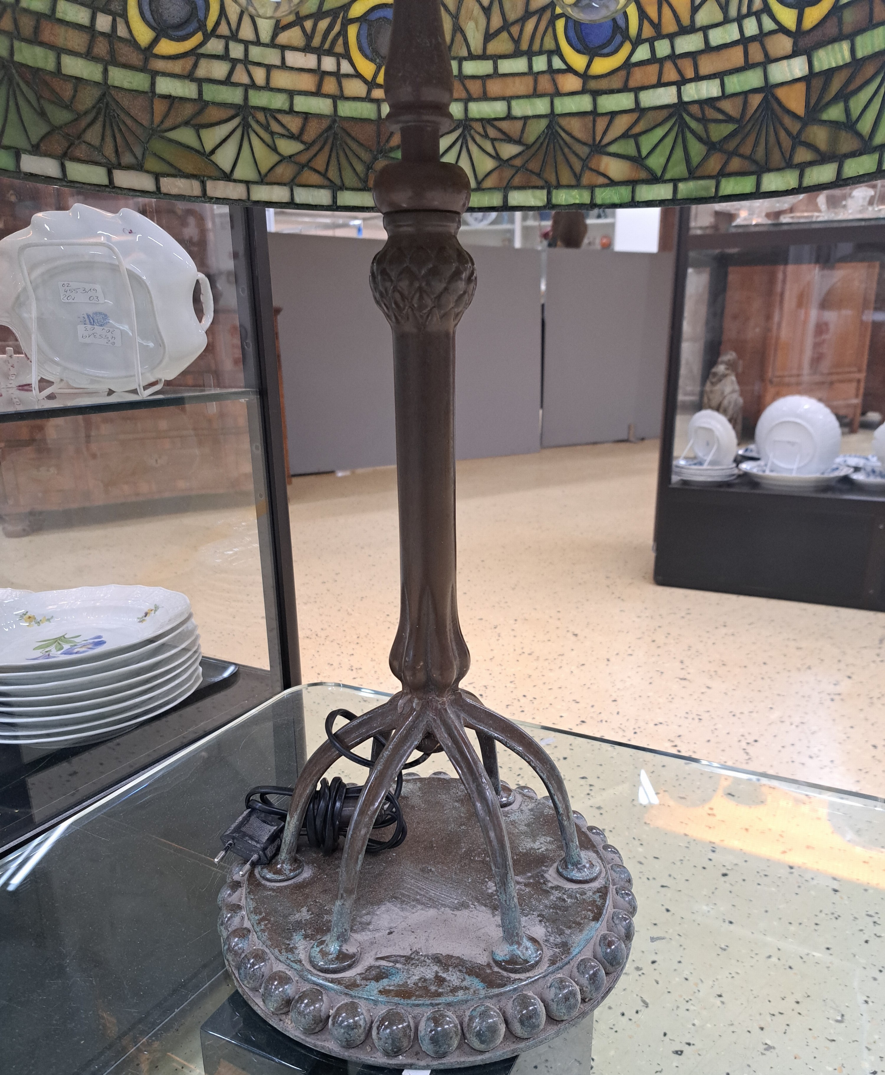 Detail d: Tiffany-Stil-Lampe, USA, 20. Jh., großer Glasmosaikschirm im Pfauenaugendekor, patinierter Bronzefuß auf runder Bodenplatte , sechs hohen Beinen ...