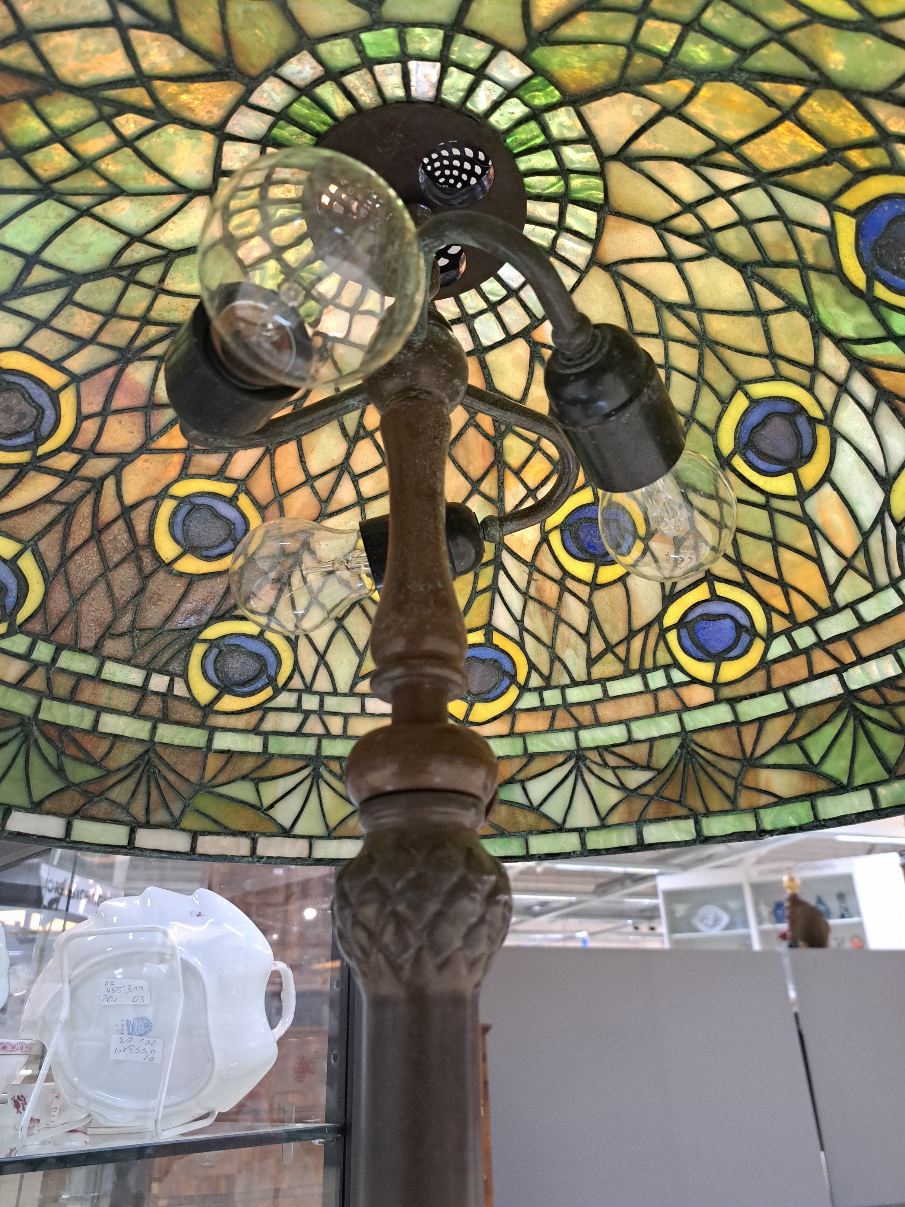 Detail e: Tiffany-Stil-Lampe, USA, 20. Jh., großer Glasmosaikschirm im Pfauenaugendekor, patinierter Bronzefuß auf runder Bodenplatte , sechs hohen Beinen ...