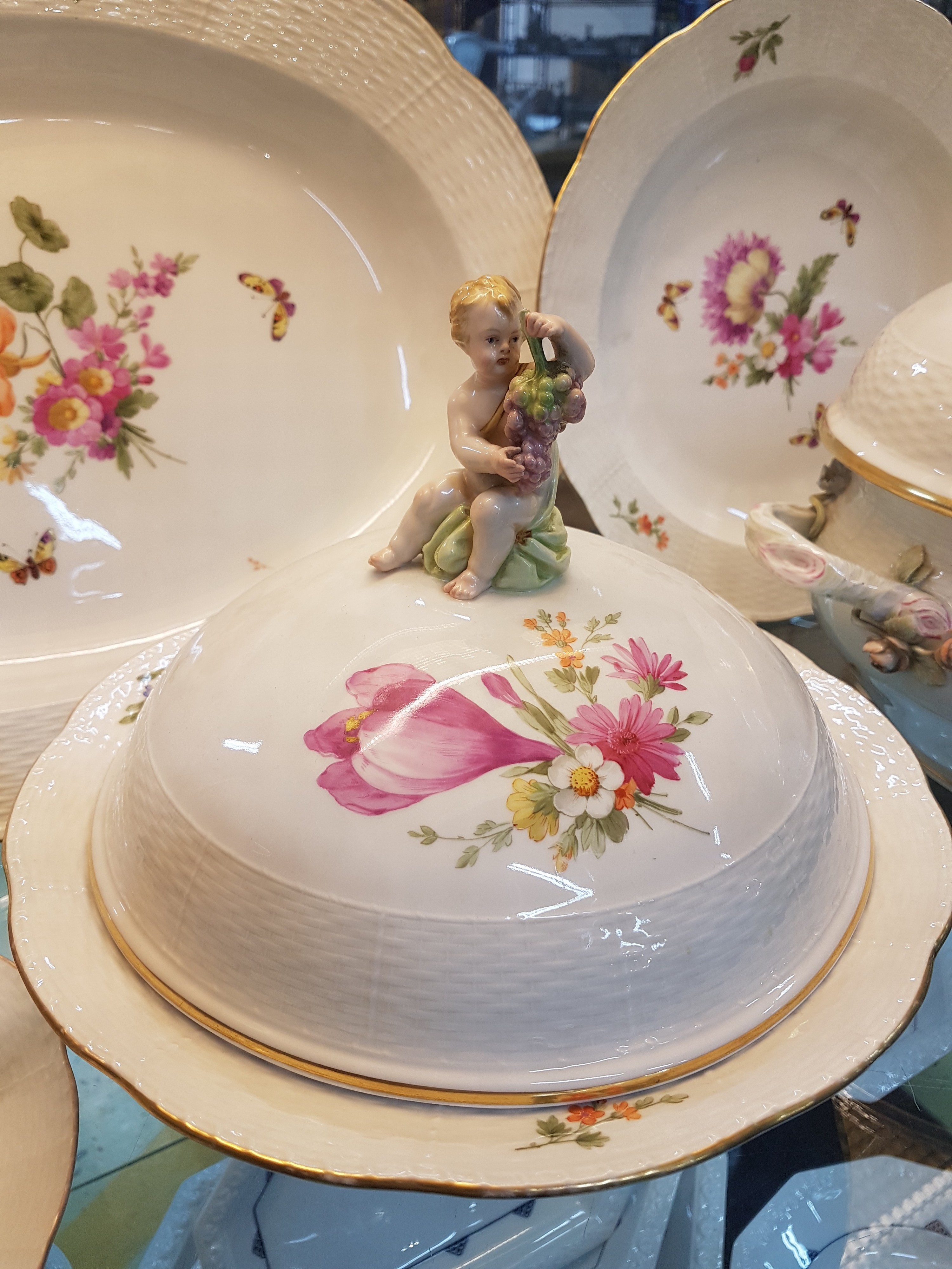 Detail l: Teile eines Tafelservice, KPM, Berlin, Anfang 20.Jh., Porzellan, Alt-Ozier, Reliefzier, handbemalter Dekor mit Streublumen und Schmetterlingen, ...
