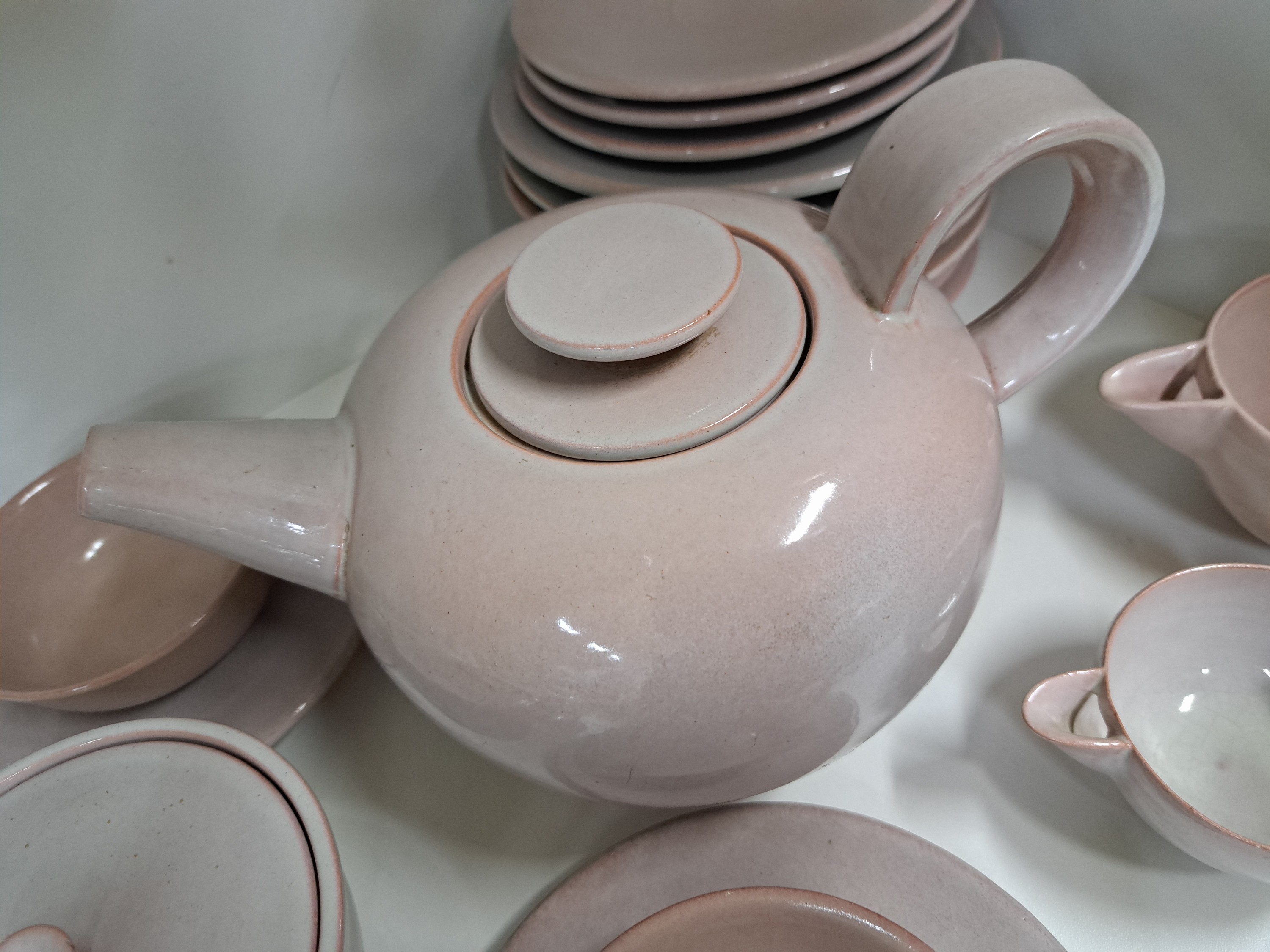 Detail e: Serviceteile, Otto Lindig (1895-1966) für Karlsruher Majolika, um 1923, Modellnr. 4004, hellrote Glasur, 7 Teller, 2 Tasse mit 5 UT, 2 Milchgießer, ...