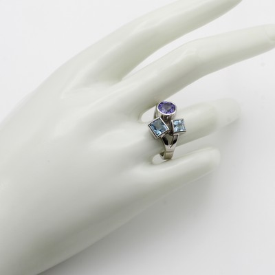 27046465b - Ring mit Farbsteinen, WG 750/000, 2 carréef. Aquam. zus. ca. 1.21 ct, runder Tansanit ...