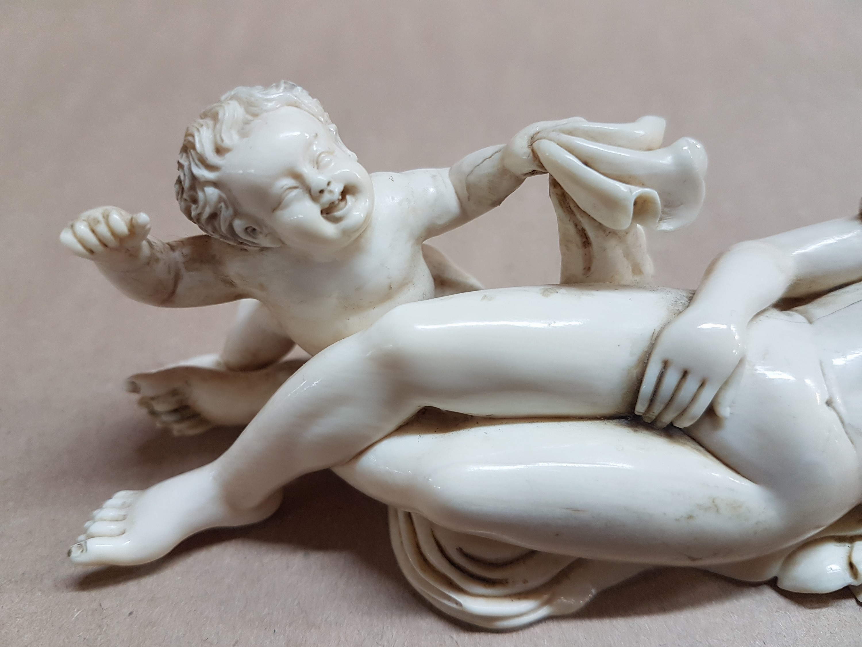 Detail f: Elfenbeinfigur, wohl flämisch, 17./18. Jh., liegende Venus mit Amor, die Göttin hat ihren Kopf auf einem Kissen liegen, mit einer Hand verdeckt sie ...